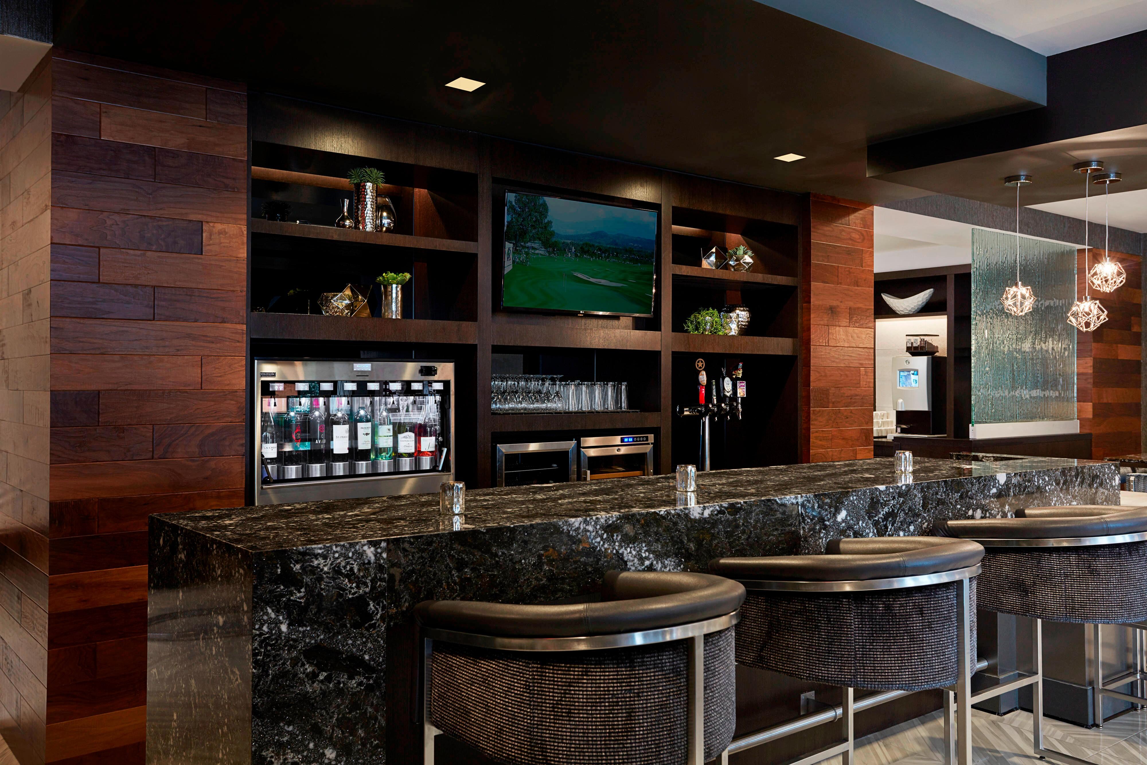 Black-and-white bar and chairs with beverages and glassware on shelves