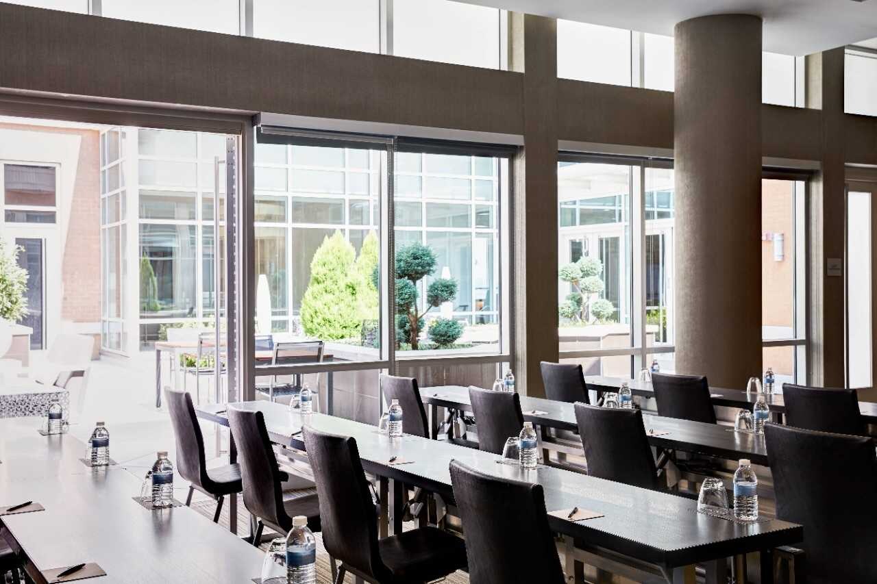 Rows of meeting tables beside floor-to-ceiling windows.