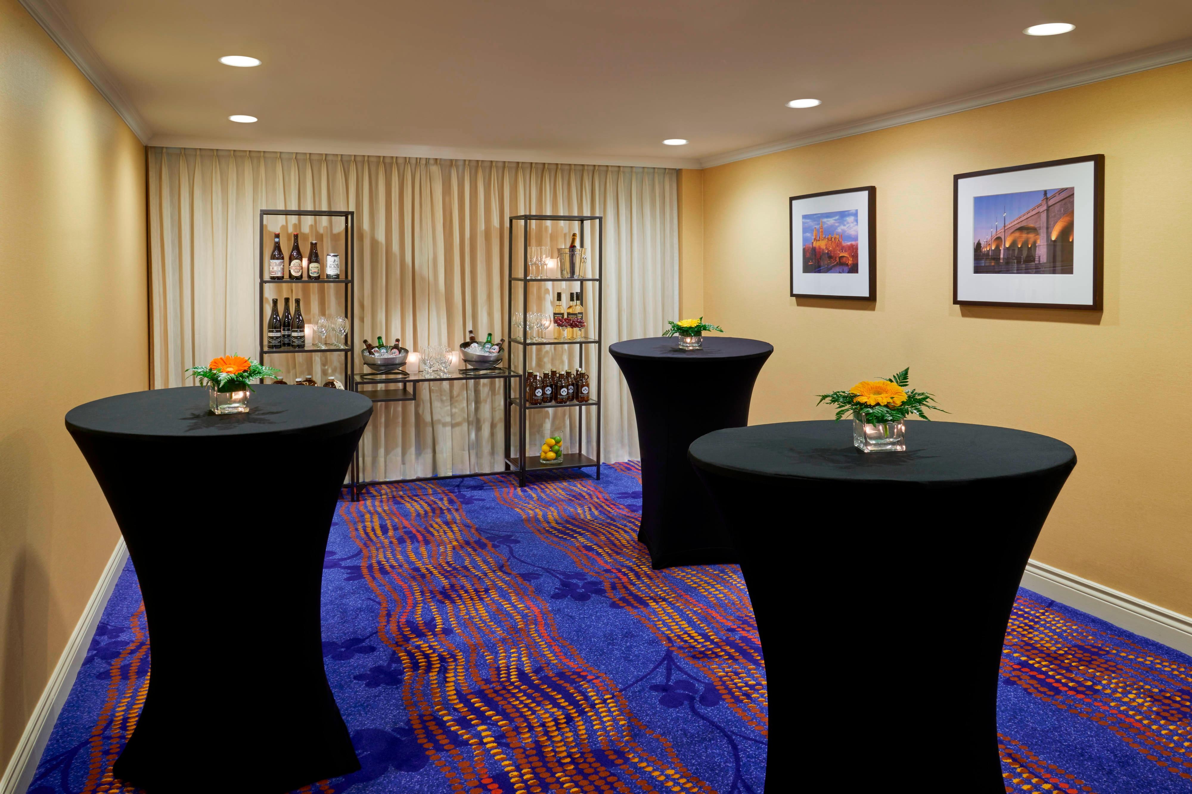 Black pedestals with flowers and beverage assortment