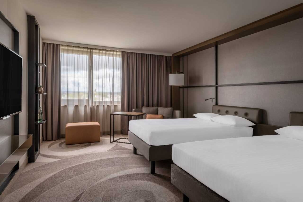 Guest room with two beds and exterior view.