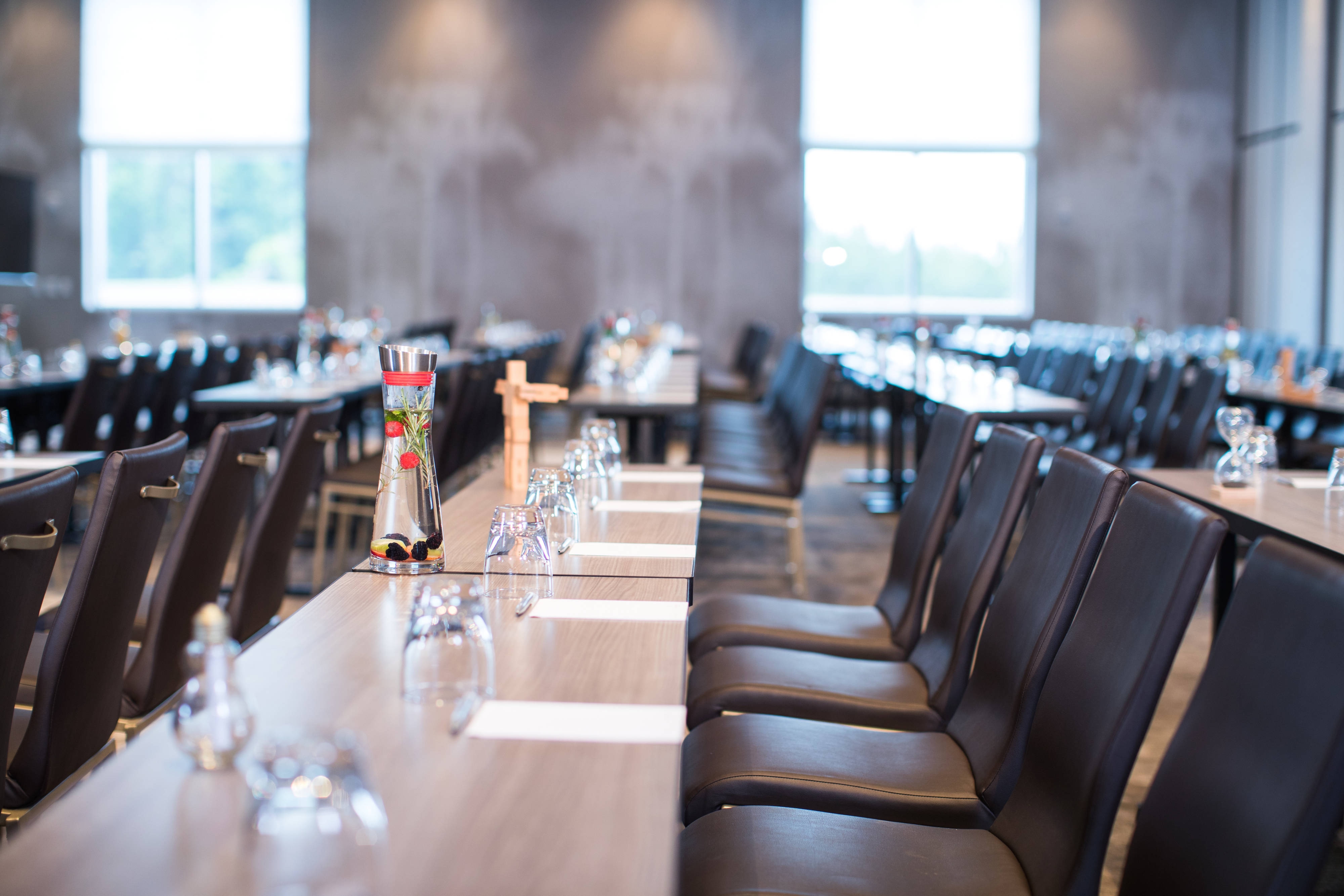 Rows of tables with water glasses and notepads