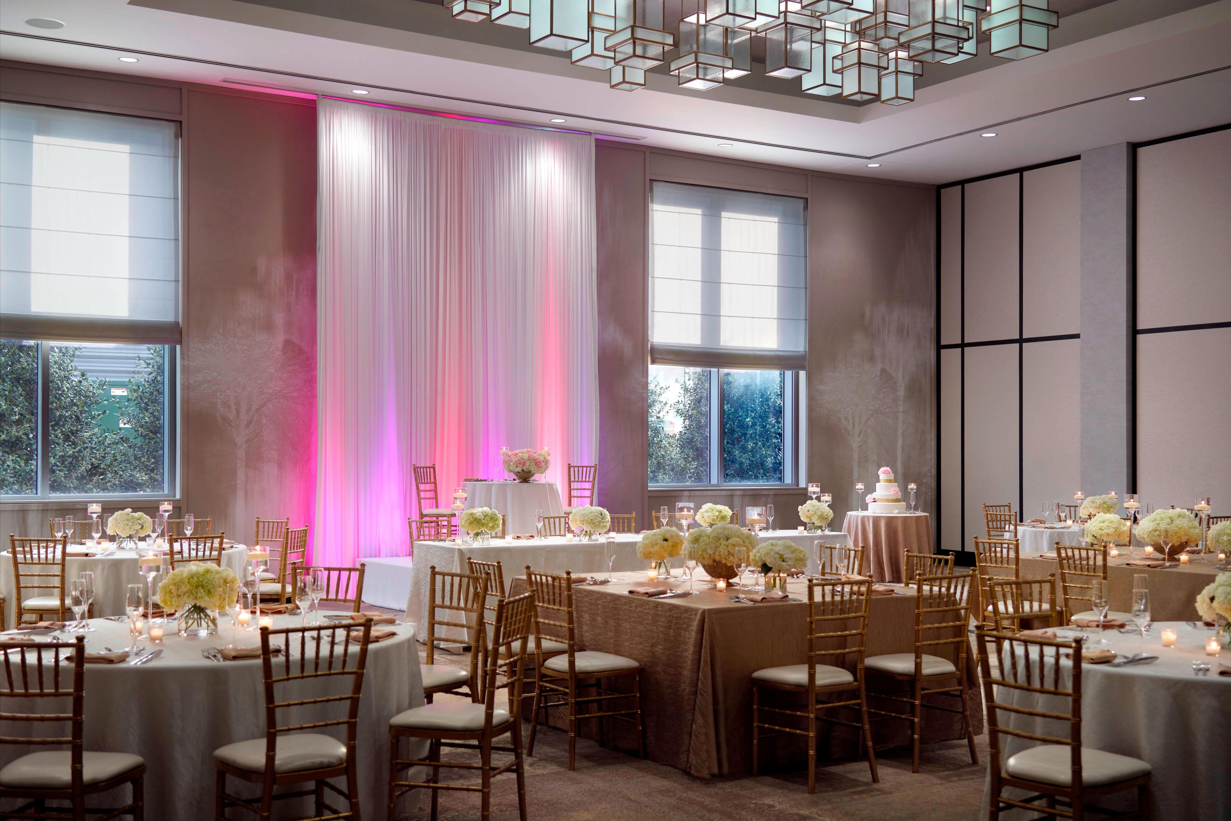 Ballroom wedding reception with pink accent lighting
