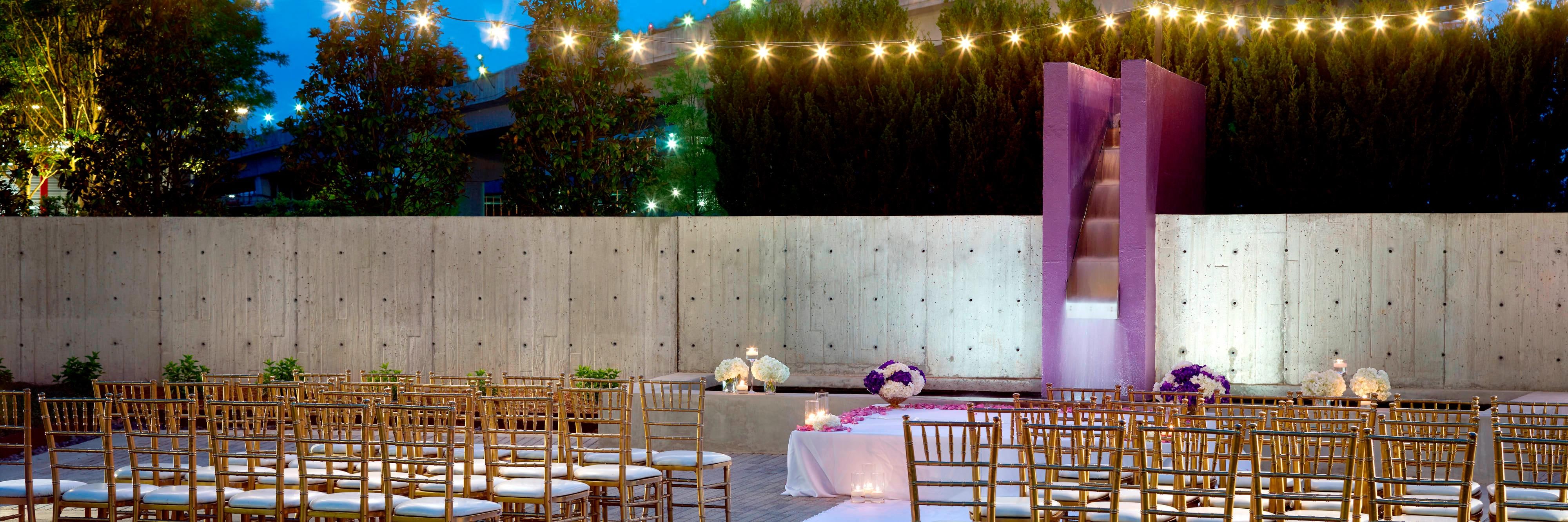 Outdoor wedding on terrace with string lights and water feature