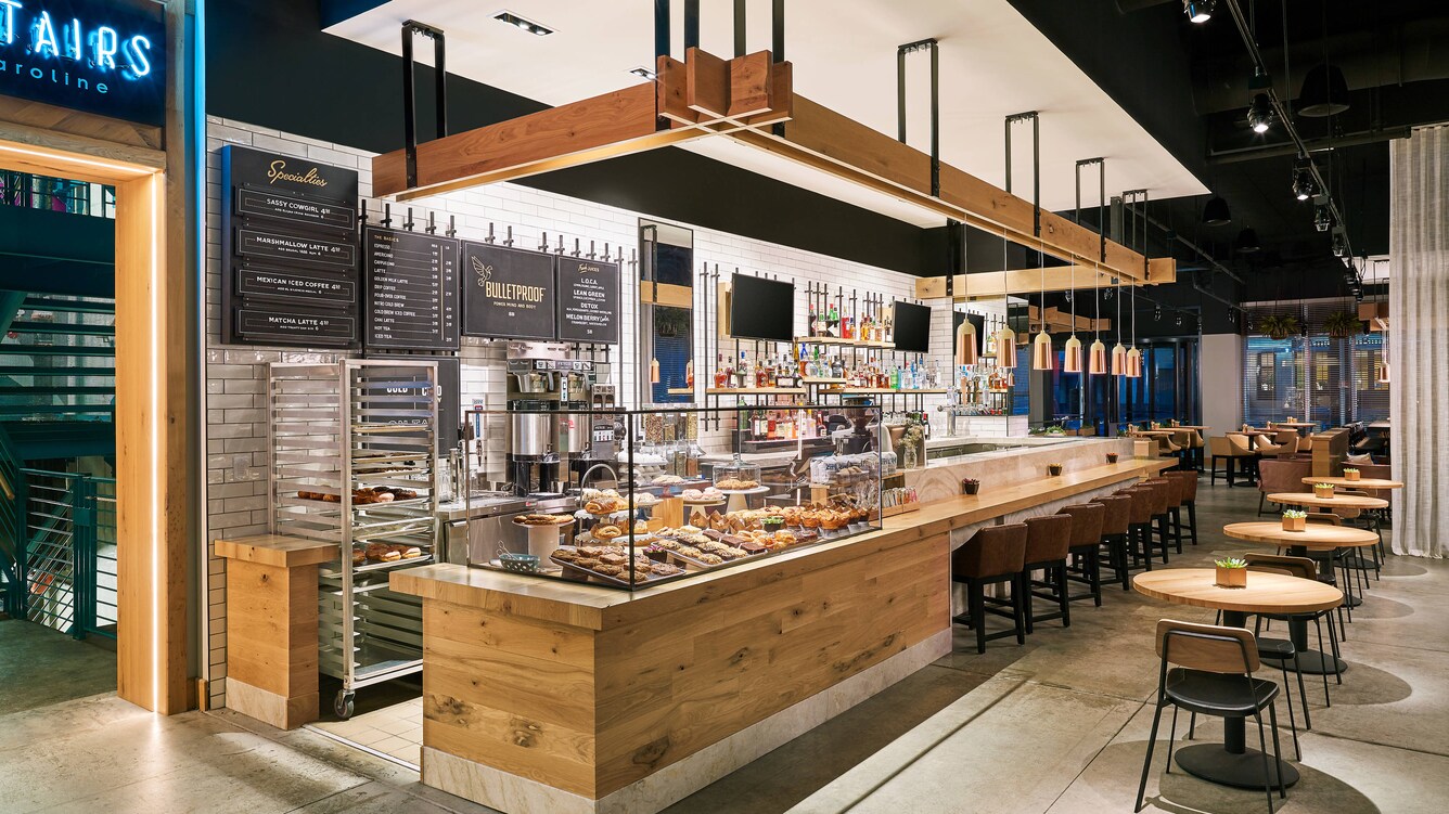 Barista counter with pastries in a glass case.