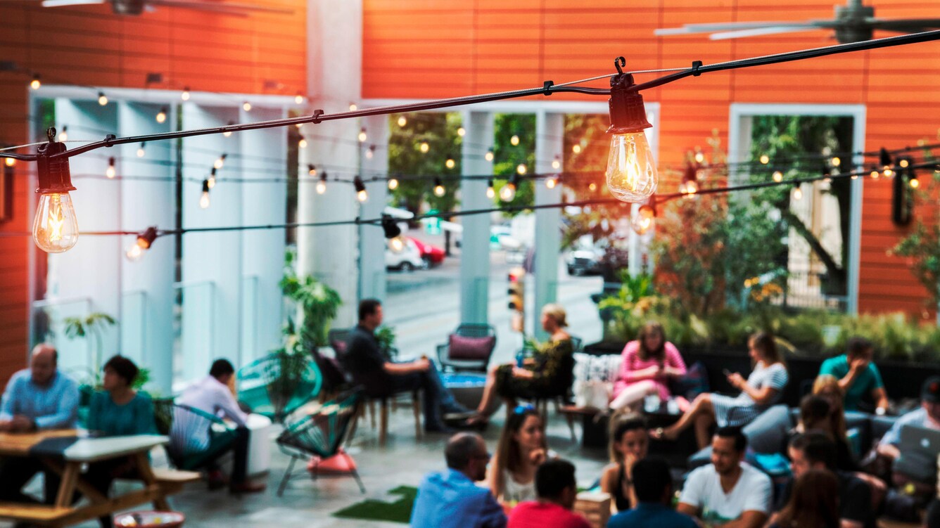 Blurry outdoor rooftop patio in background with lights in foreground.