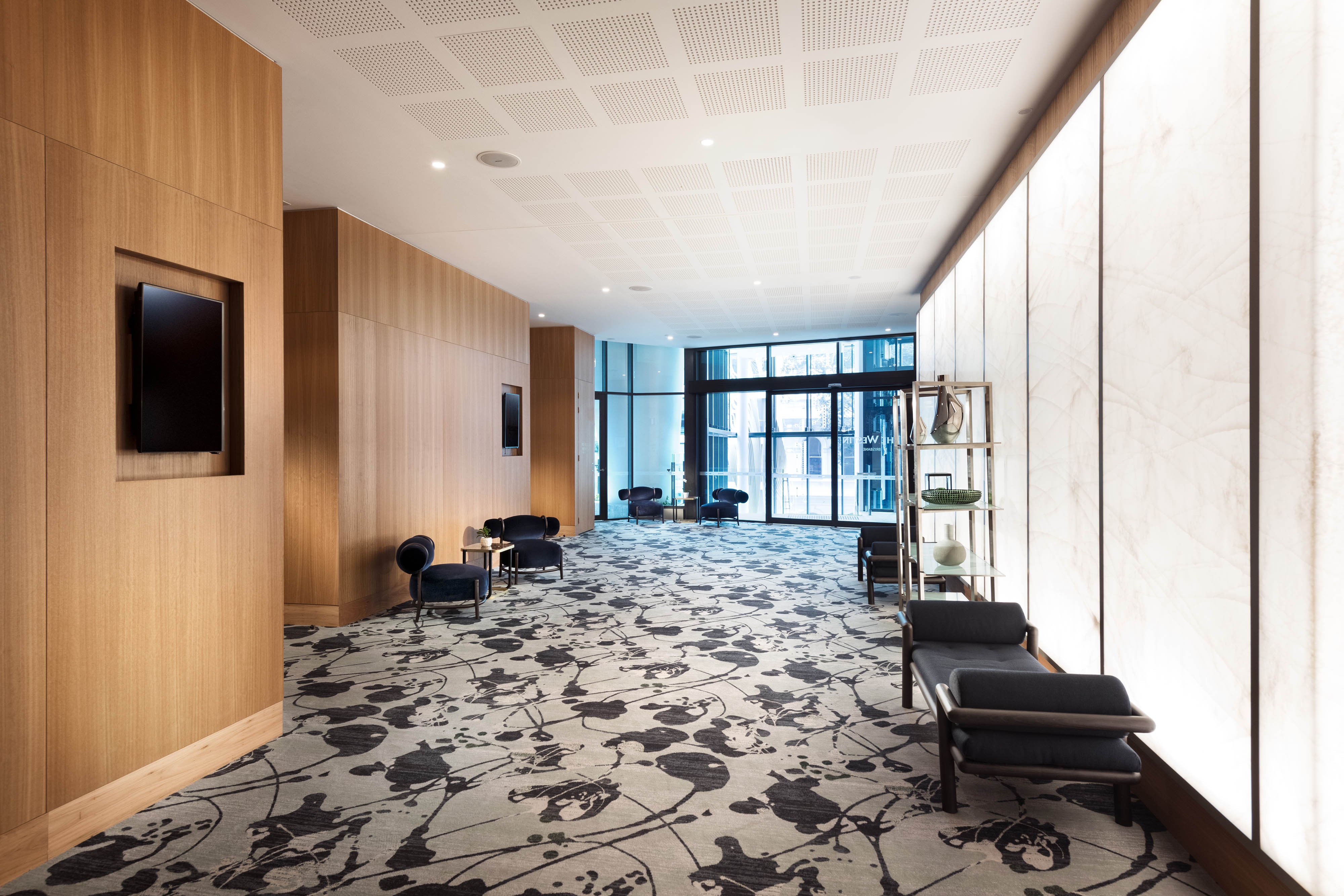 Ballroom pre-function space with padded benches and chairs and large windows