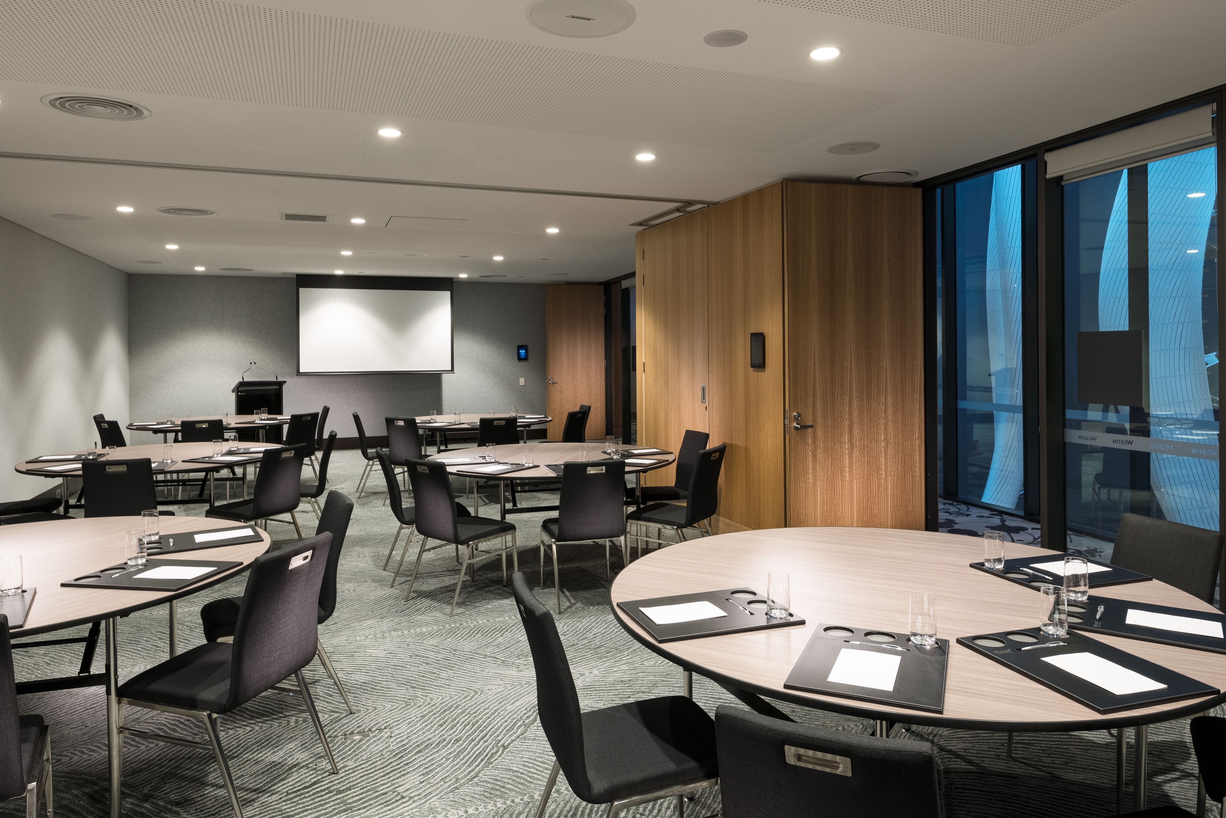 Meeting room with round tables and a projector screen
