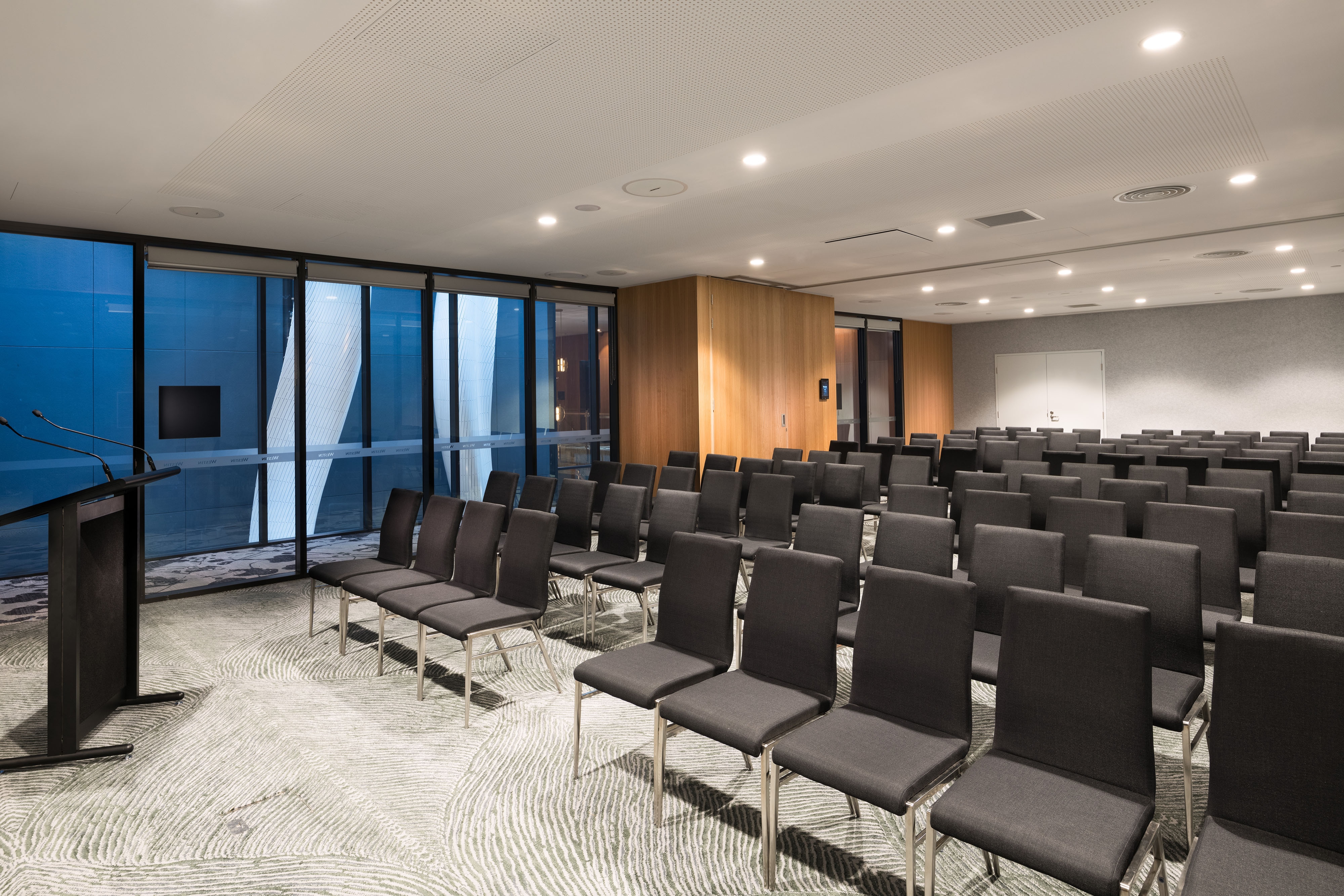 Meeting room with rows of chairs arranged in front of a podium