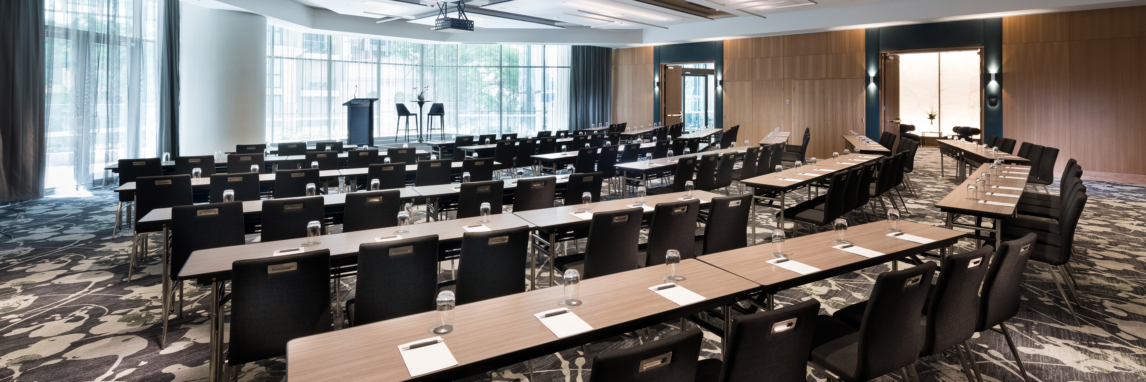 Ballroom with large windows and meeting tables arranged in a classroom style setup