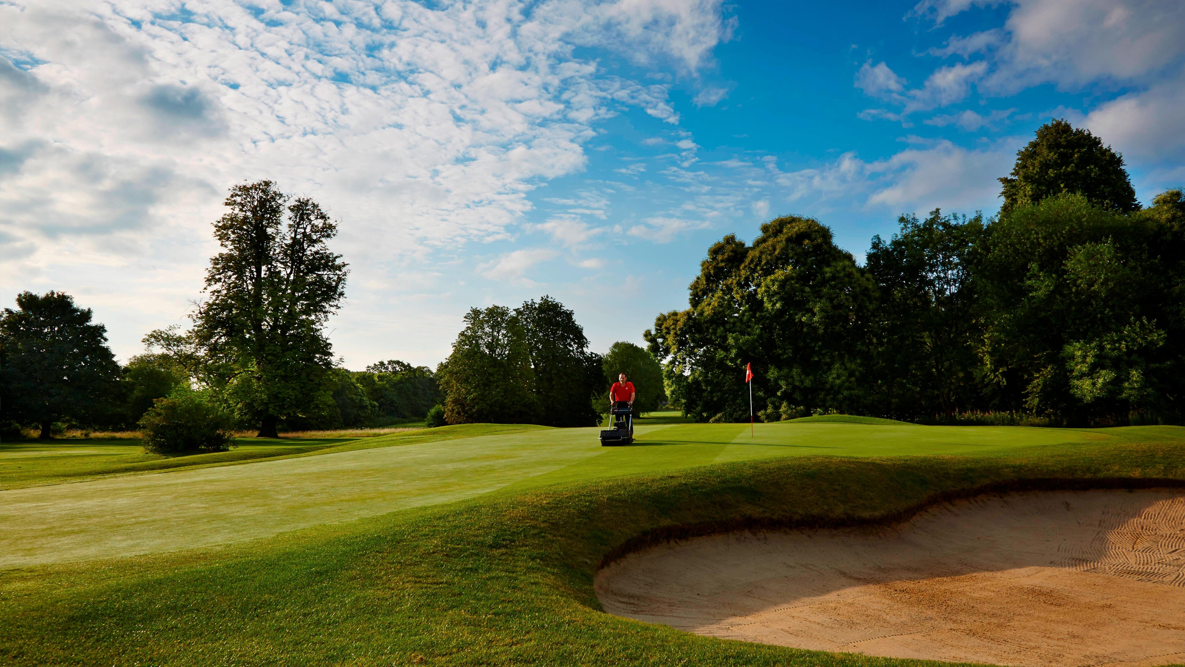 Person mowing golf course