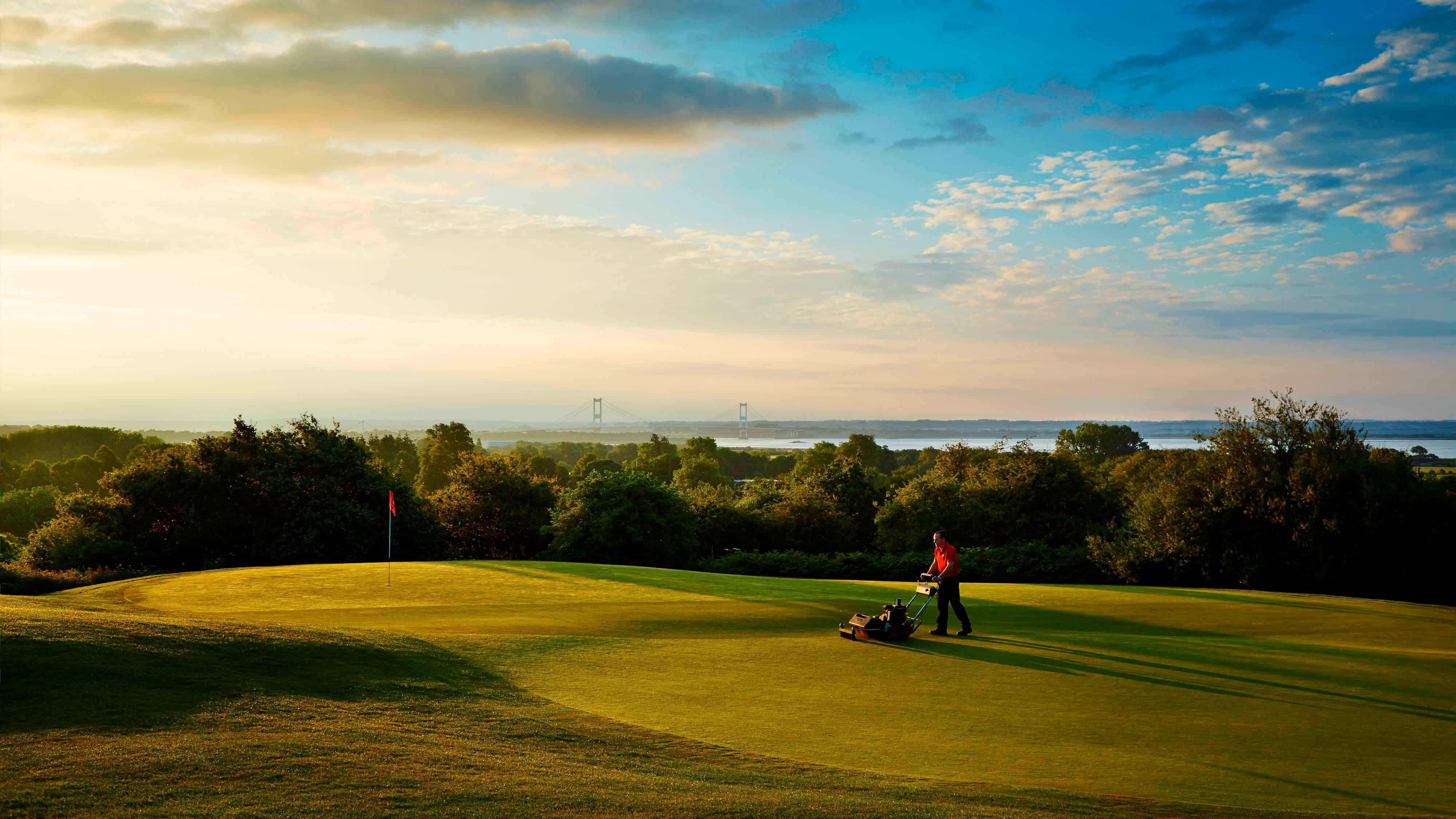 Person mowing golf course