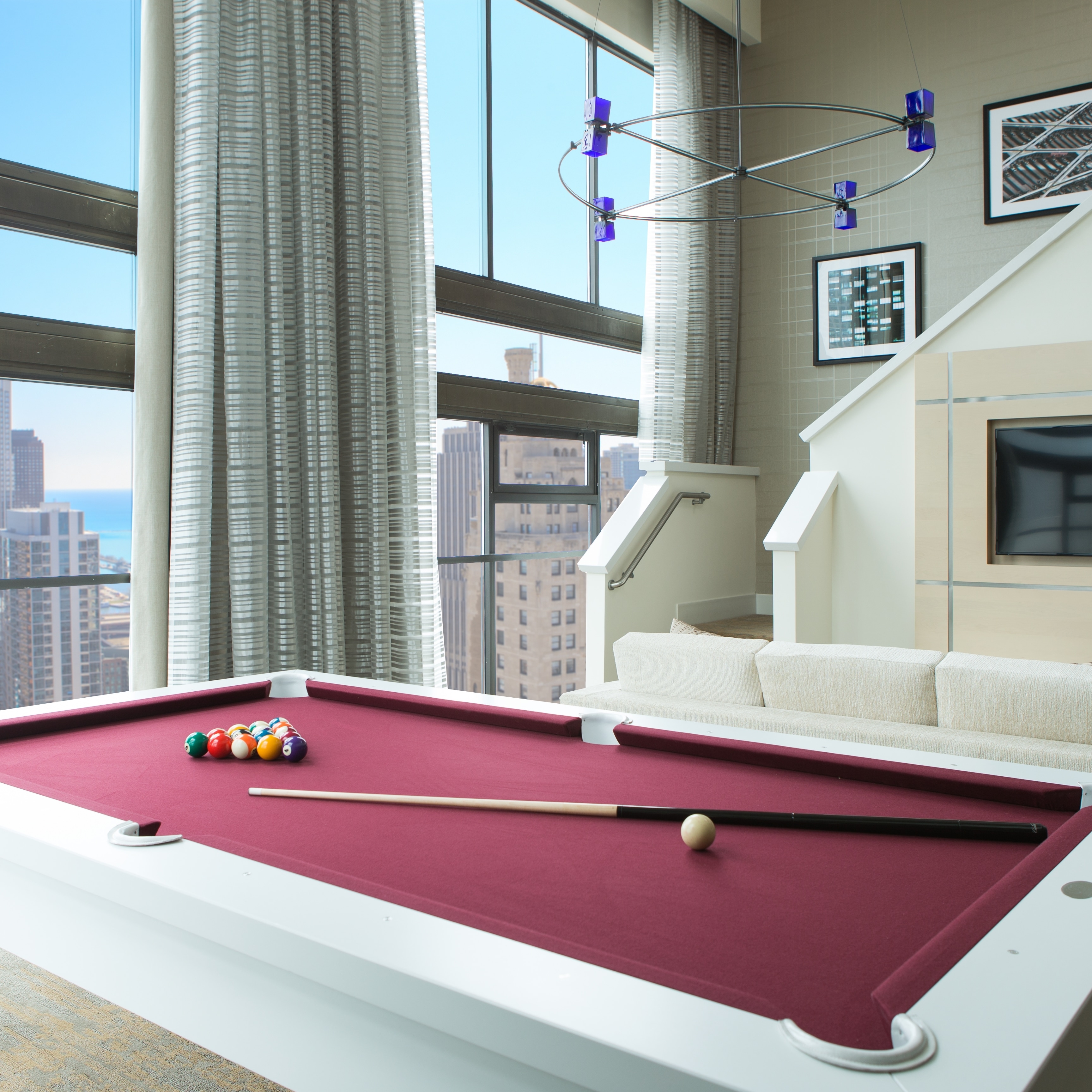 Pool table with large windows and city view
