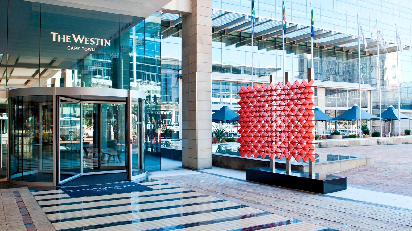 Hotel entrance with large windows and revolving door.