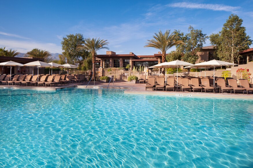 Large pool with view of poolside seating and cabanas.