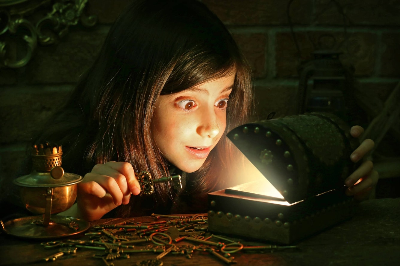 girl opening a box with a key