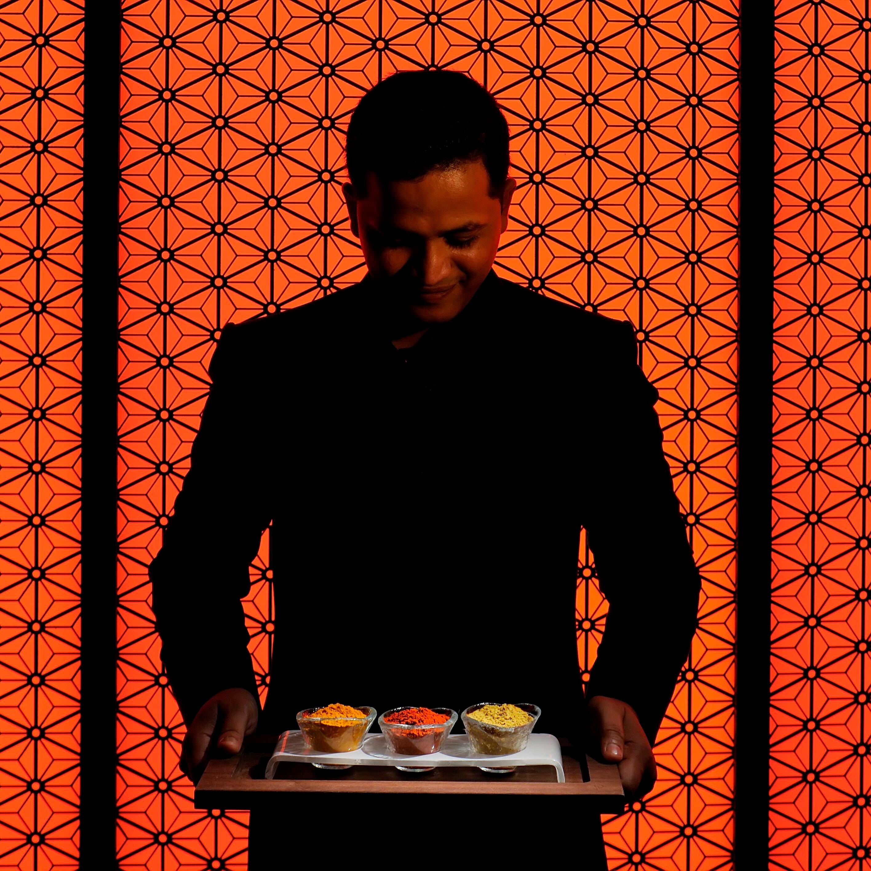 Person holding a tray of spices