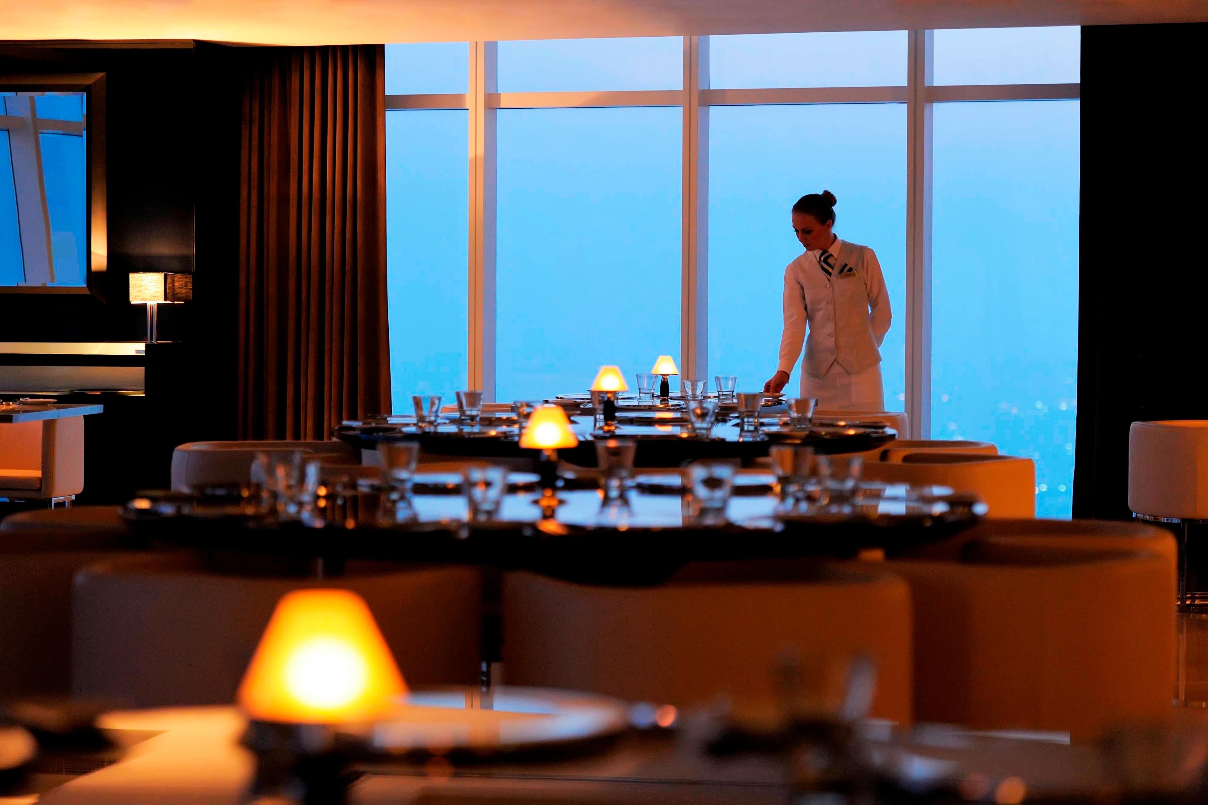 Restaurant staff setting a dining table
