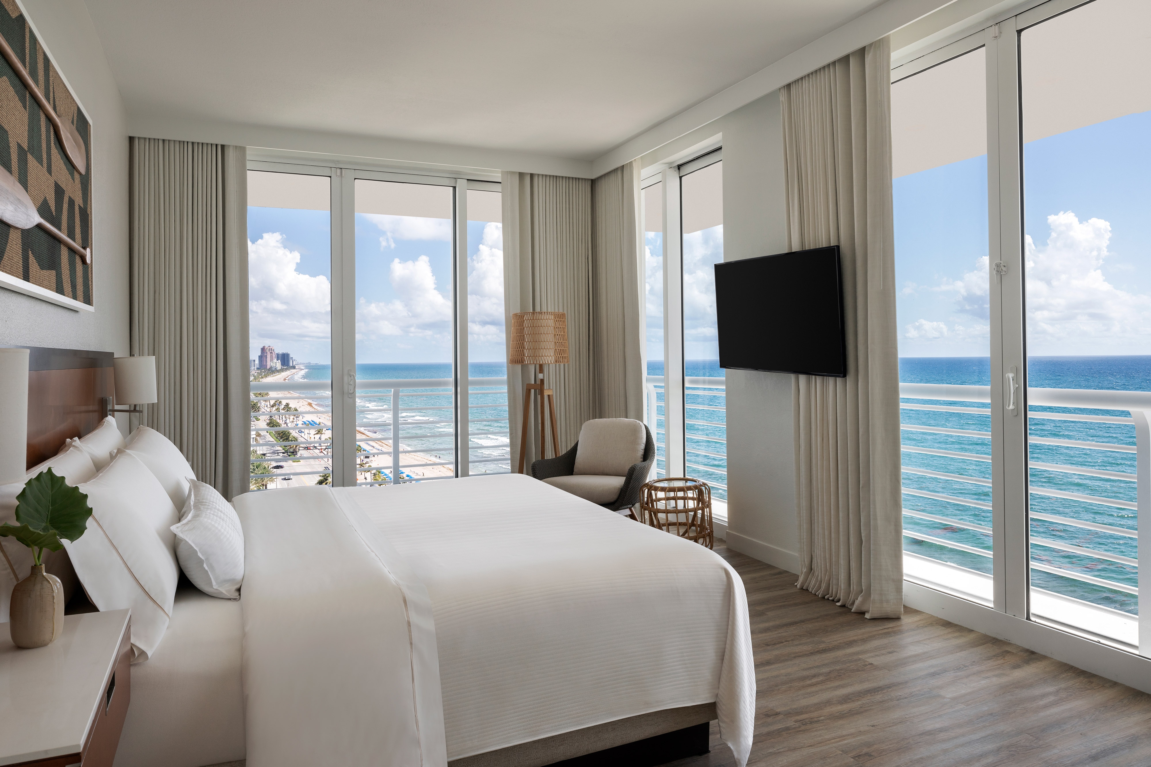 King bed with floor to ceiling windows and ocean view