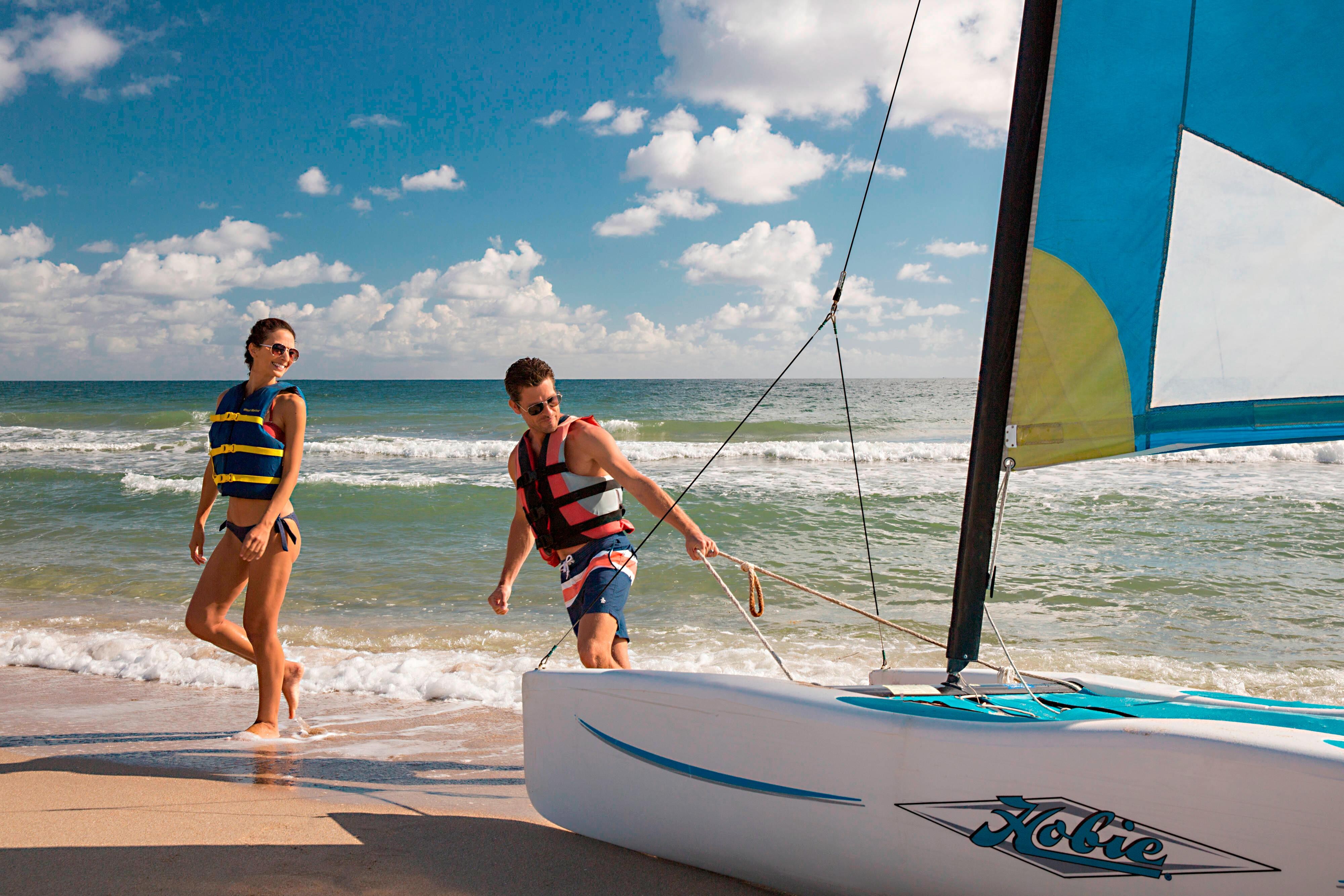 People taking a sailboat to the water