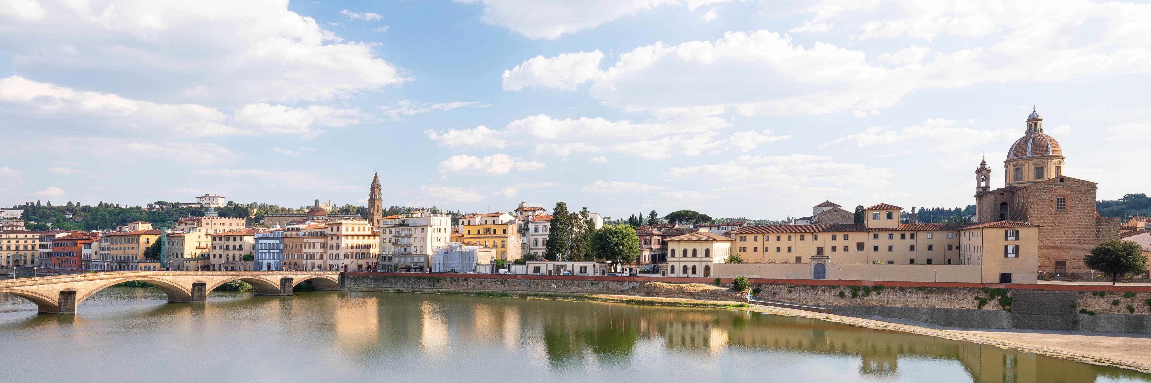 A bridge with buildings over the river