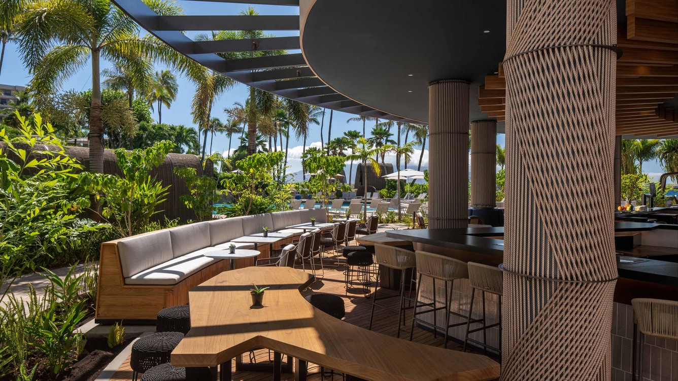 Outdoor seating area of open-air bar by beach.