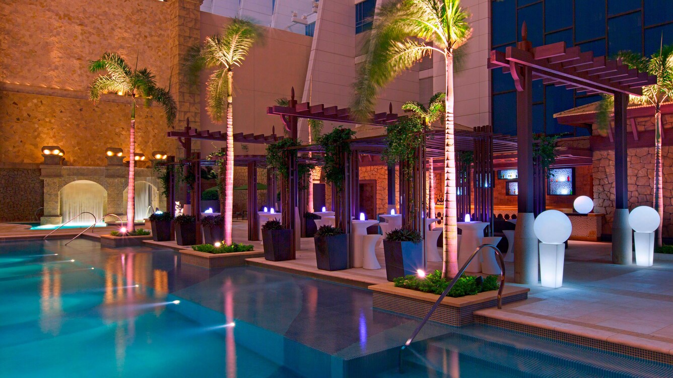 Poolside cafe at night with glowing light decorations.