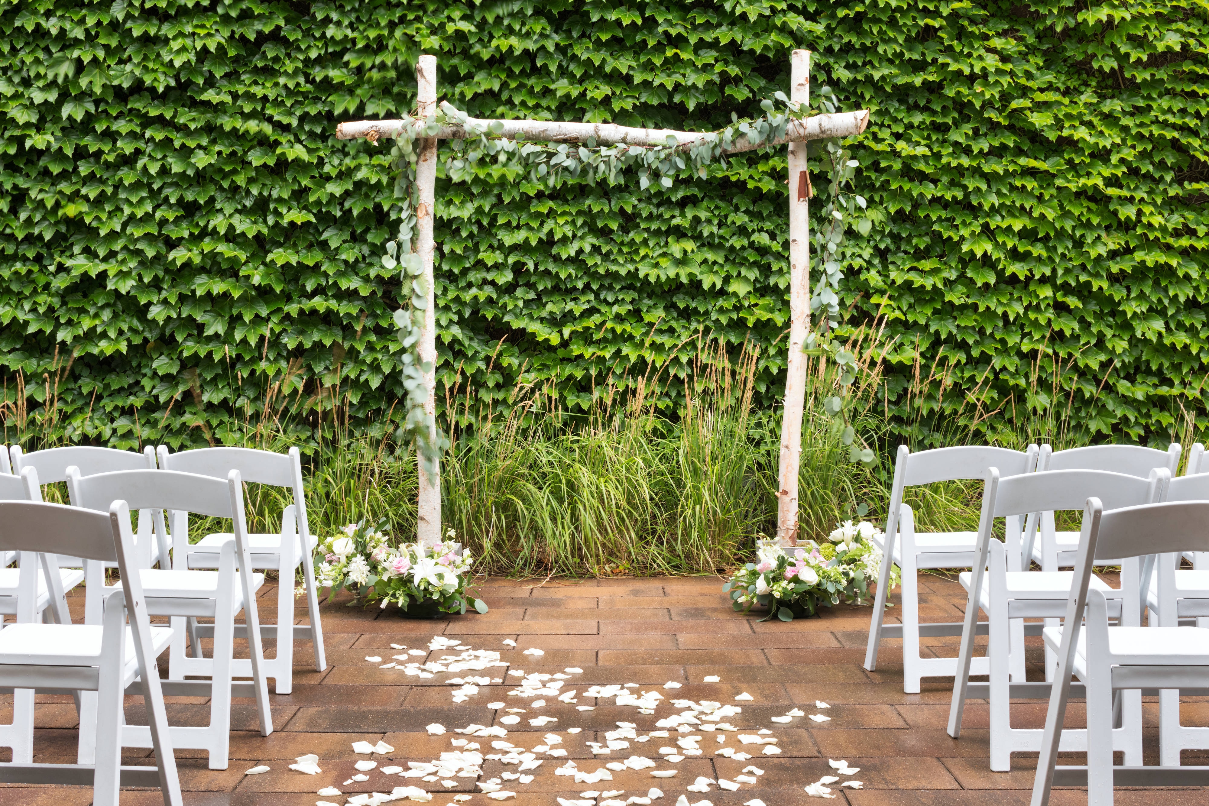 Decorative wedding arch against a wall of ivy