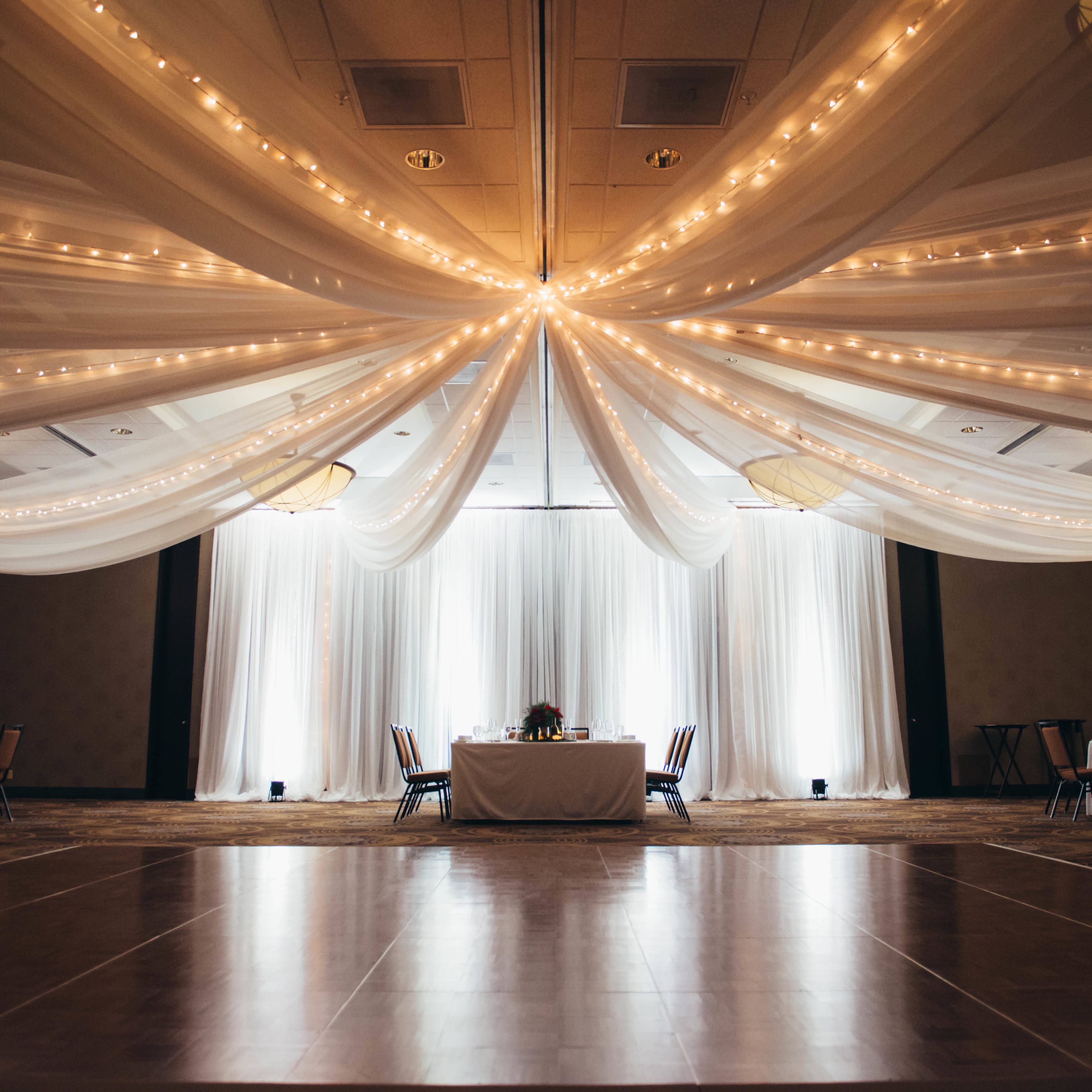 Ballroo ceiling hung with string lights and gauzy fabric