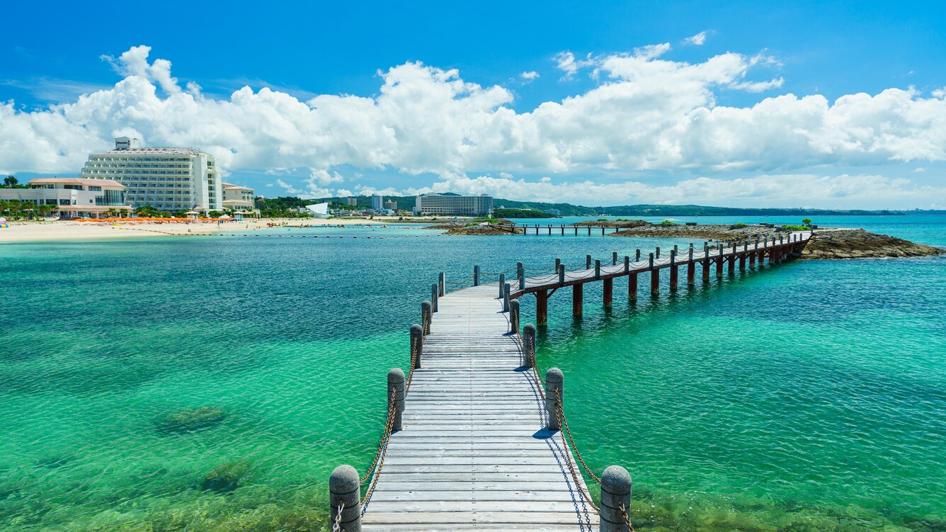 Bridge over clear leading to hotel on the beach.