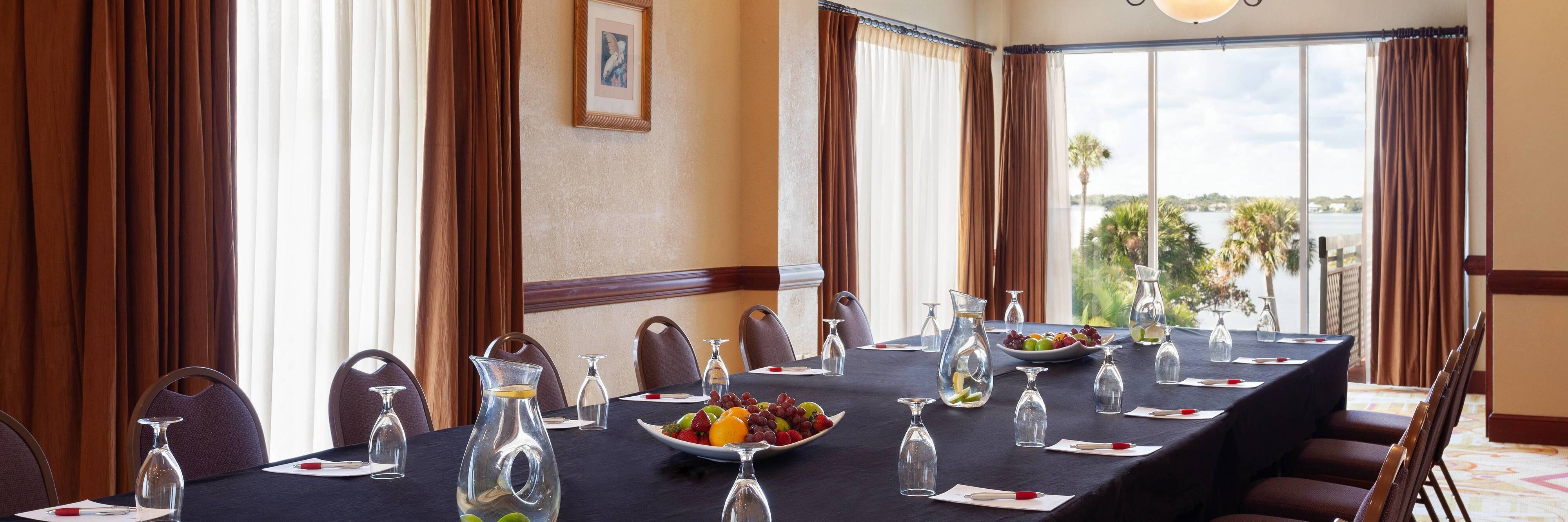 Meeting room with long conference table set with fruit trays