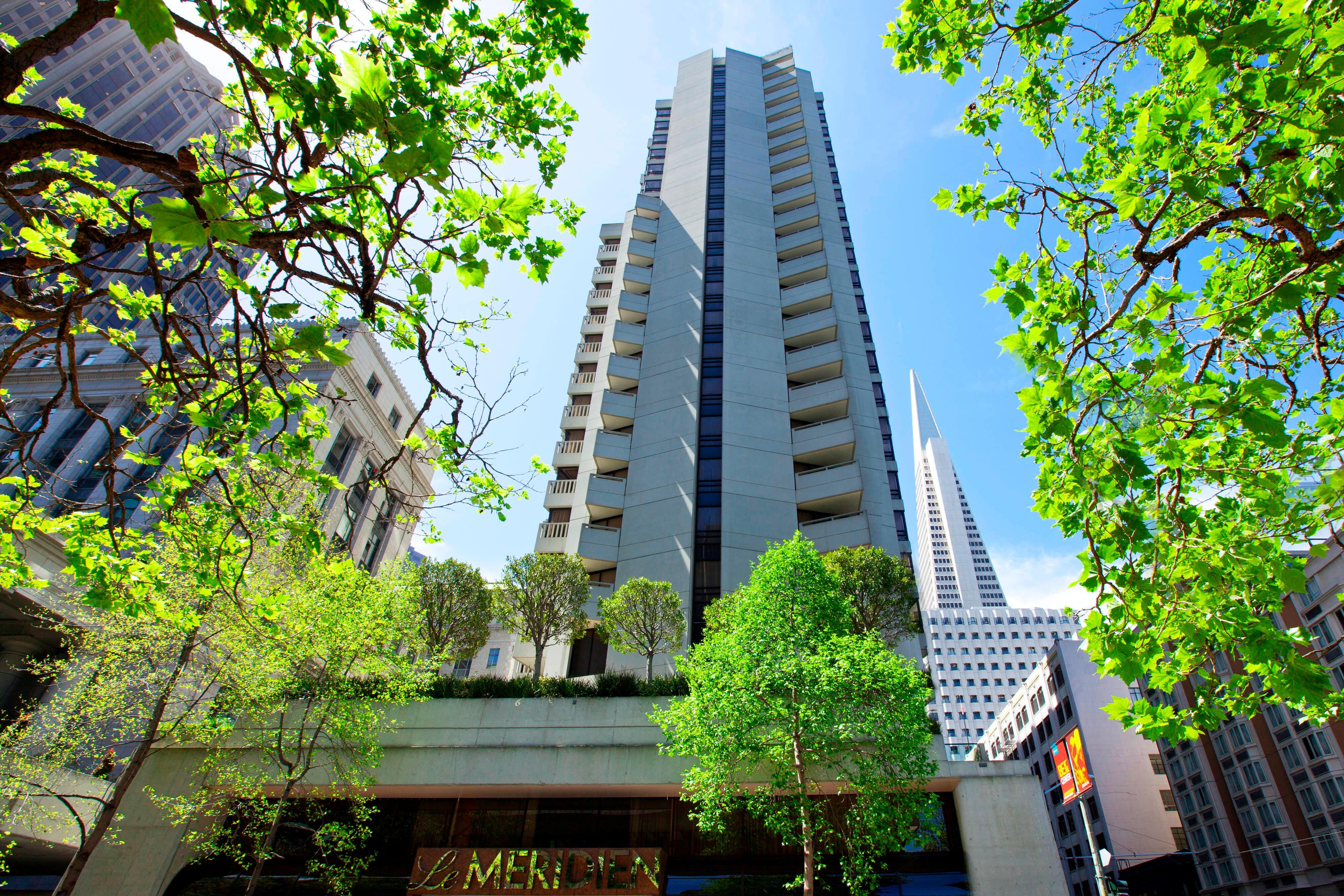 Hotel exterior. Building is very tall and is between other tall city buildings