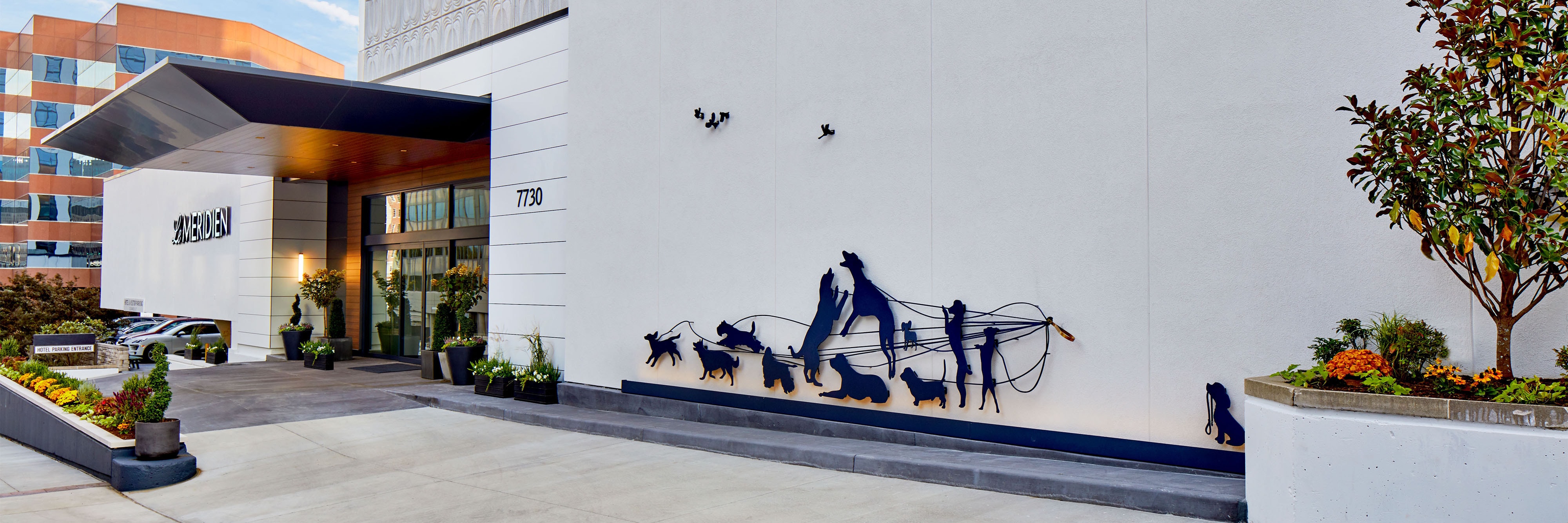 Hotel entrance with sillhouette sculpture of dogs on leashes