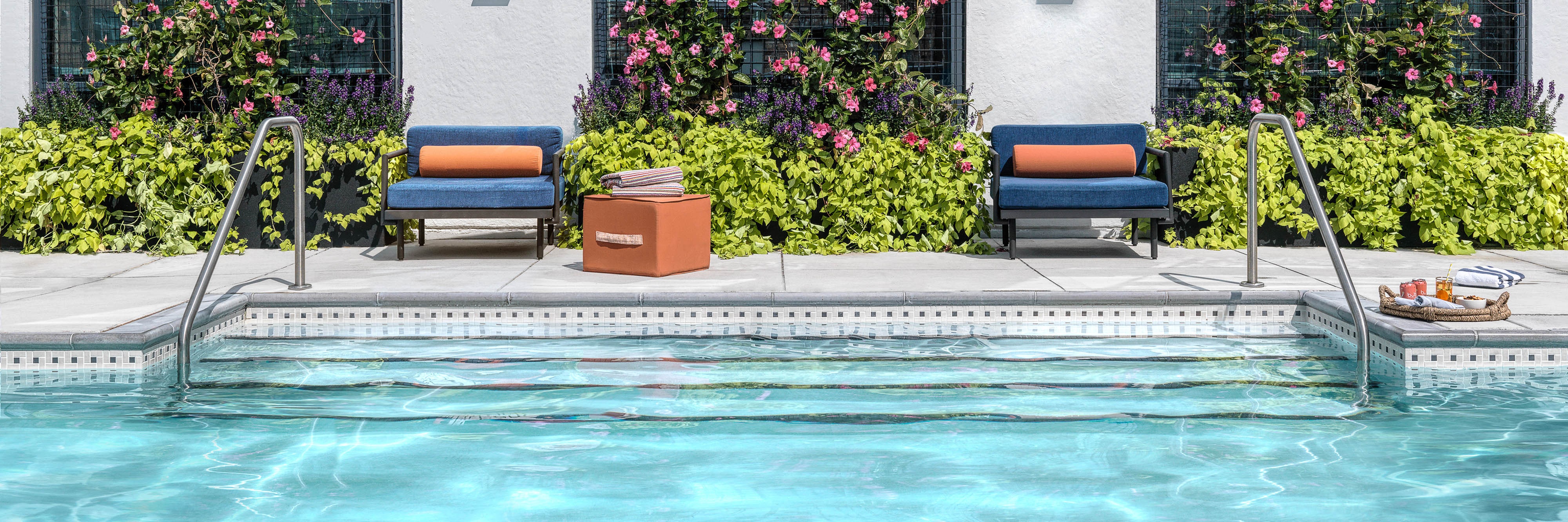 Lounge chairs beside an outdoor swimming pool