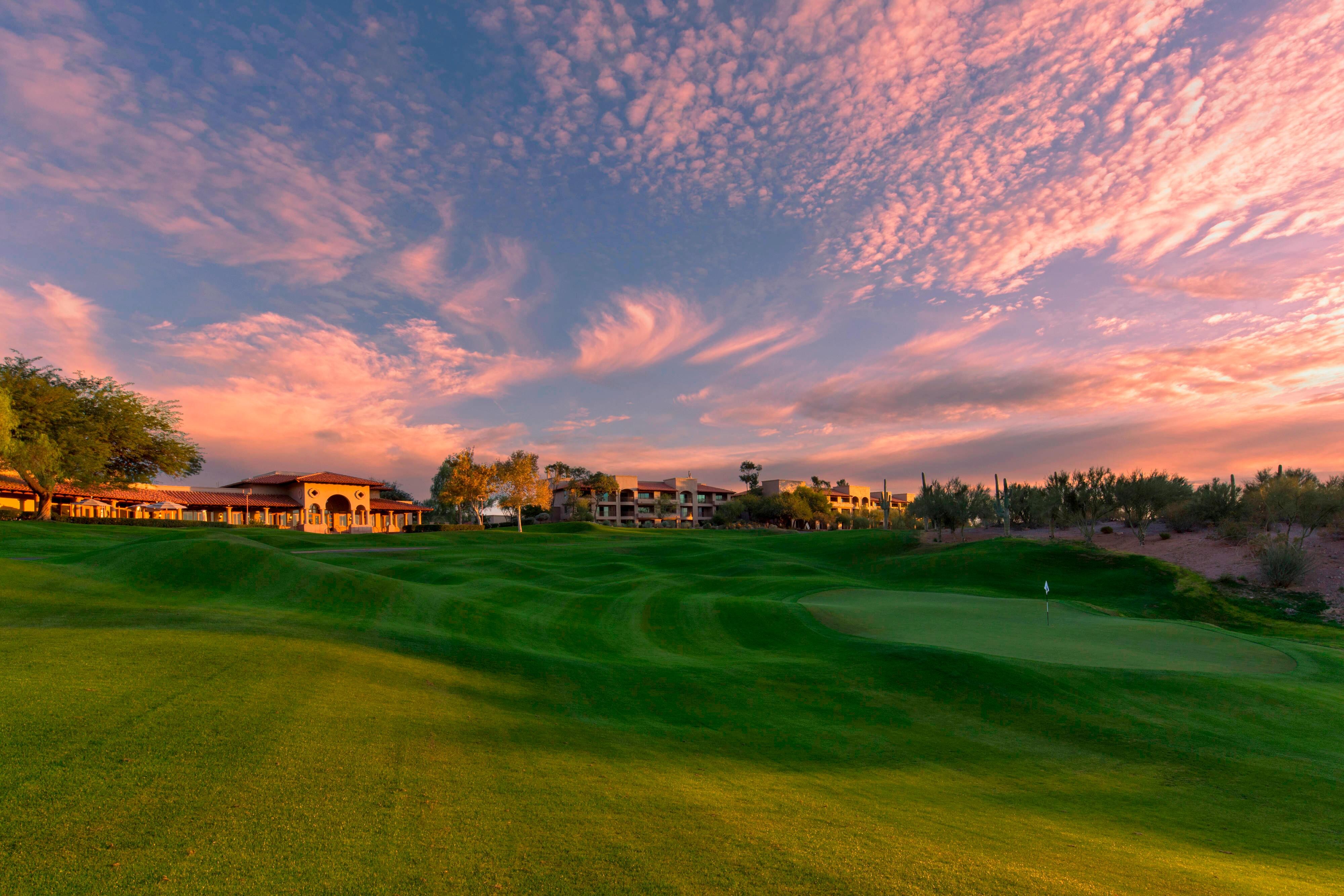 Green golf course at sunset colorful sky