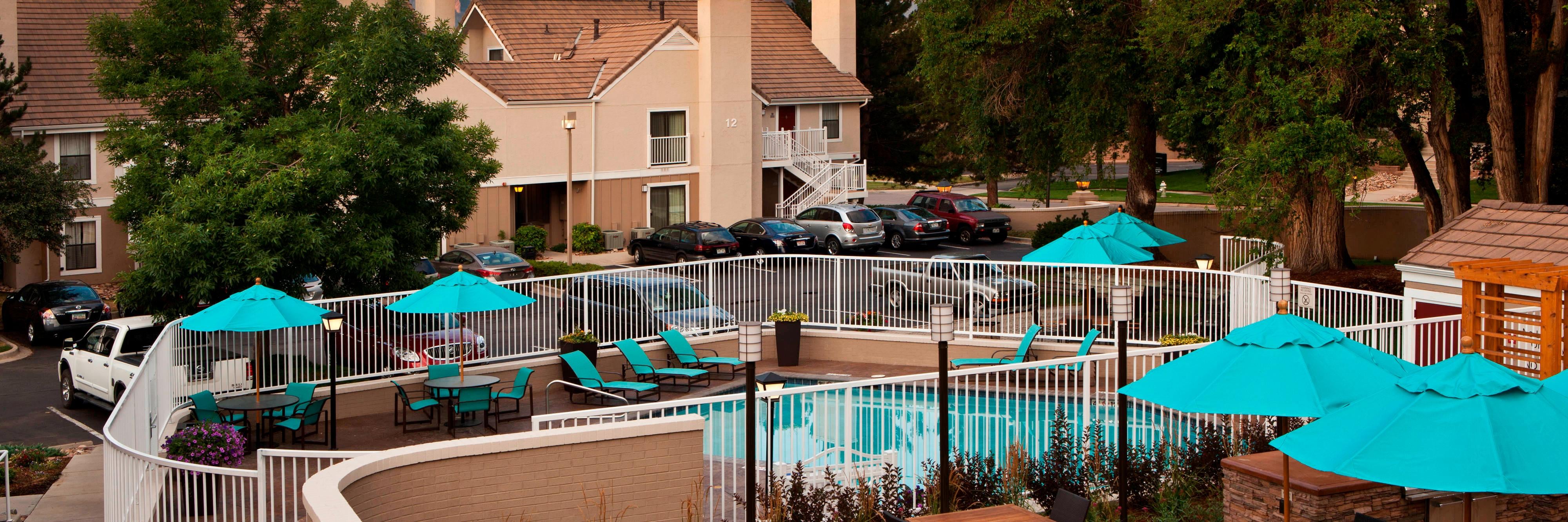Hotel exterior, courtyard seating area, and outdoor pool