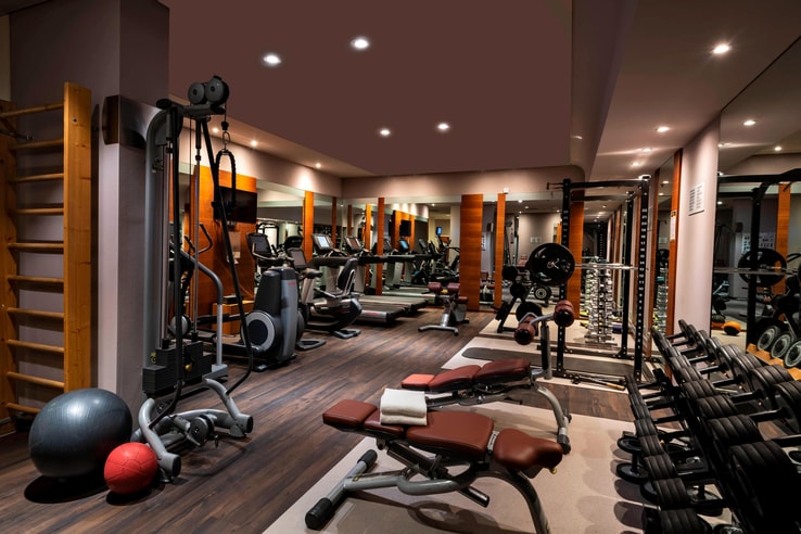 fitness room with work out equipment, machines, and benches.
