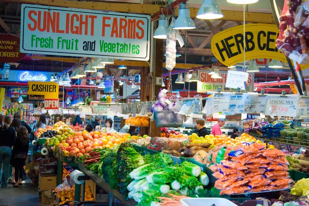 A market filled with colorful signs and fresh produce.