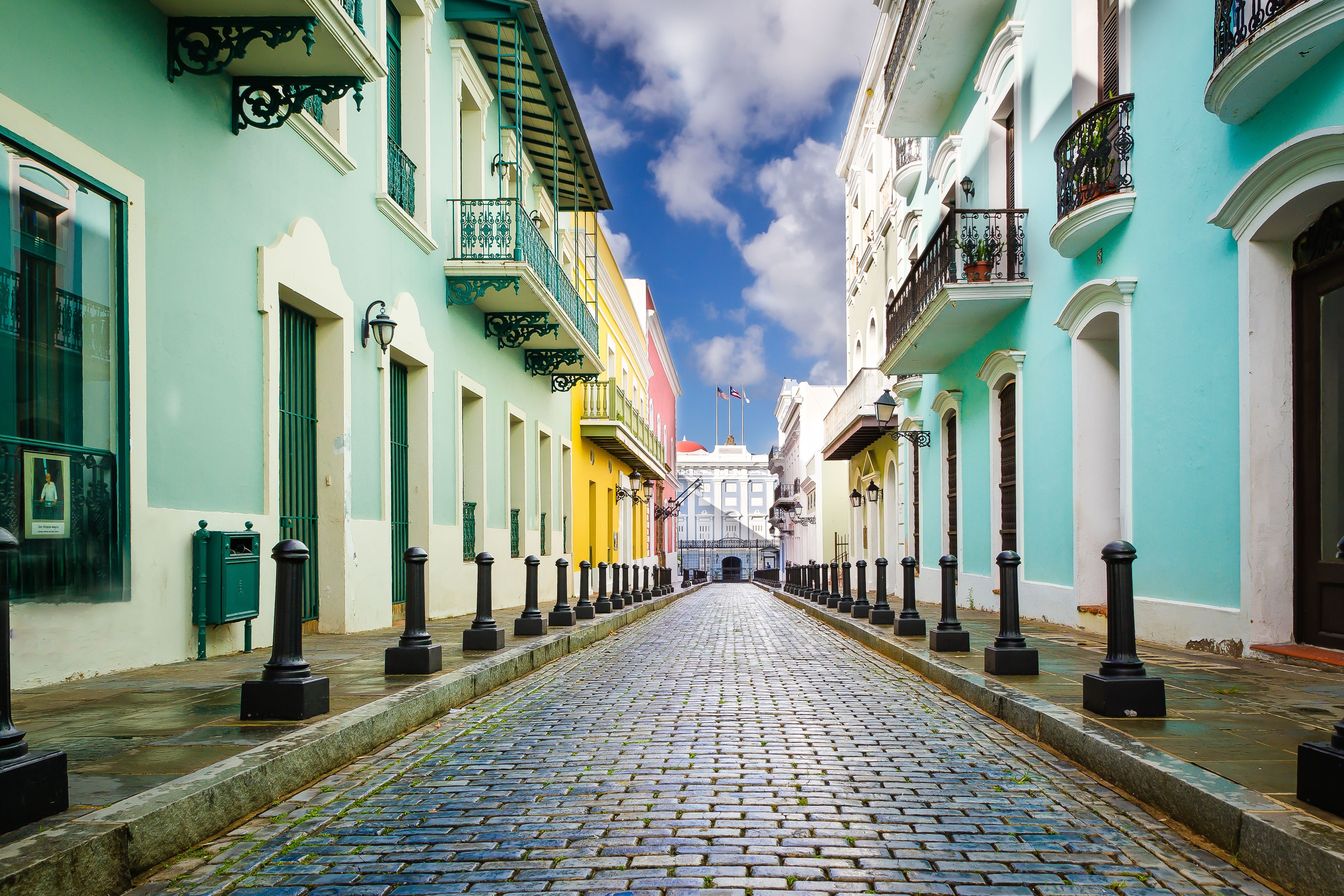 Cobblestone street with colorful buildings leading to La Fortaleza 