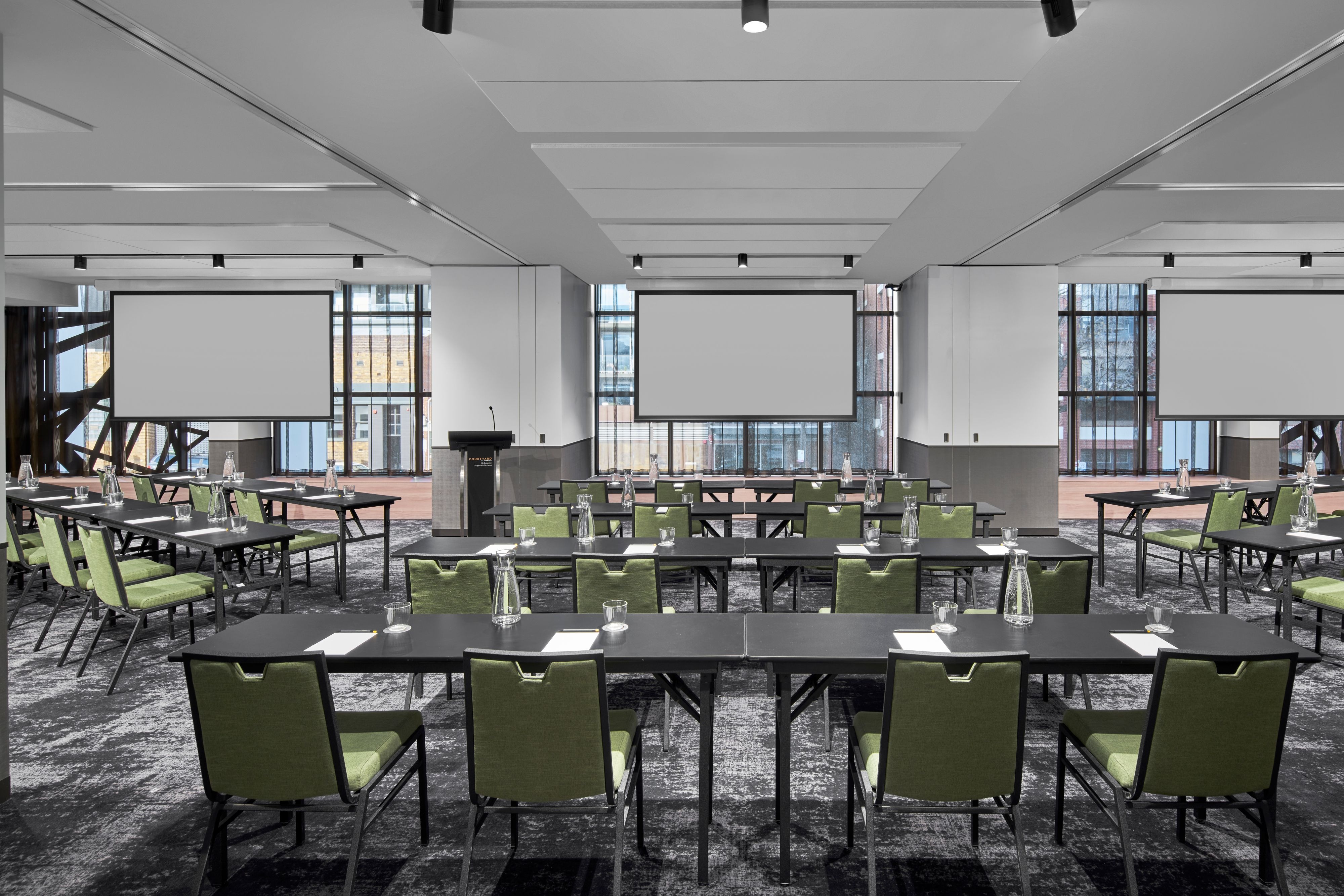 Meeting room with multiple tables and projector sreens