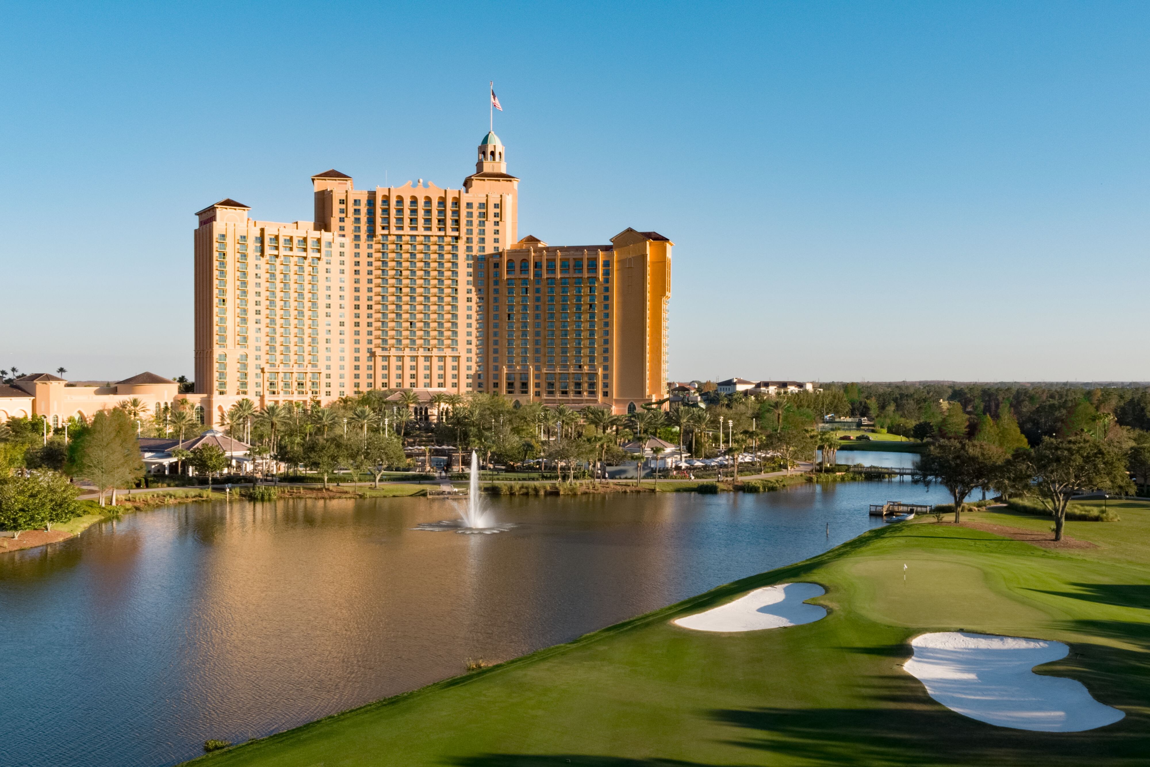 Hotel exterior. Hotel is very tall, the golf course and a large water feature as visible