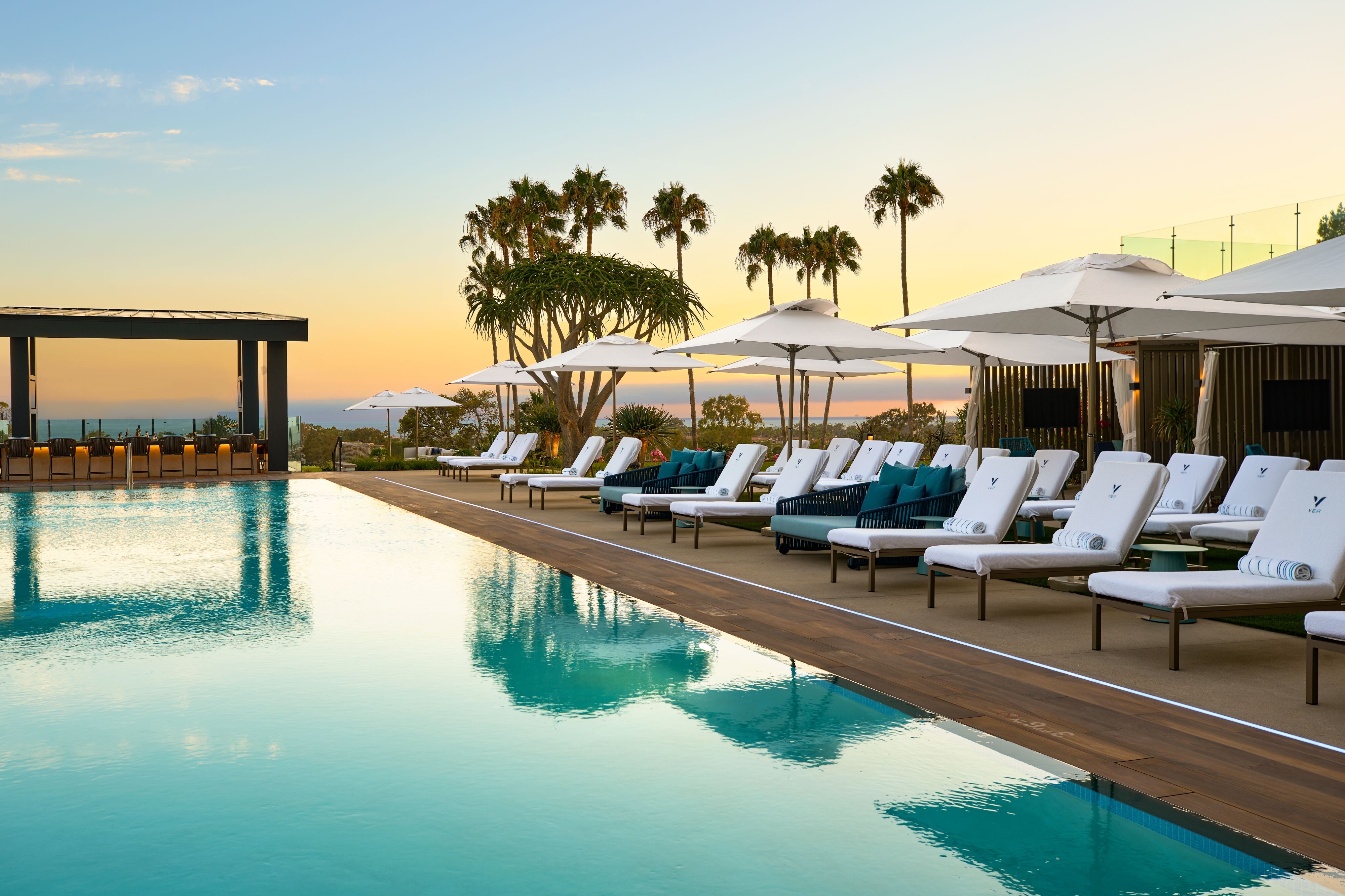 Lounge chairs and umbrellas beside the outdoor swimming pool