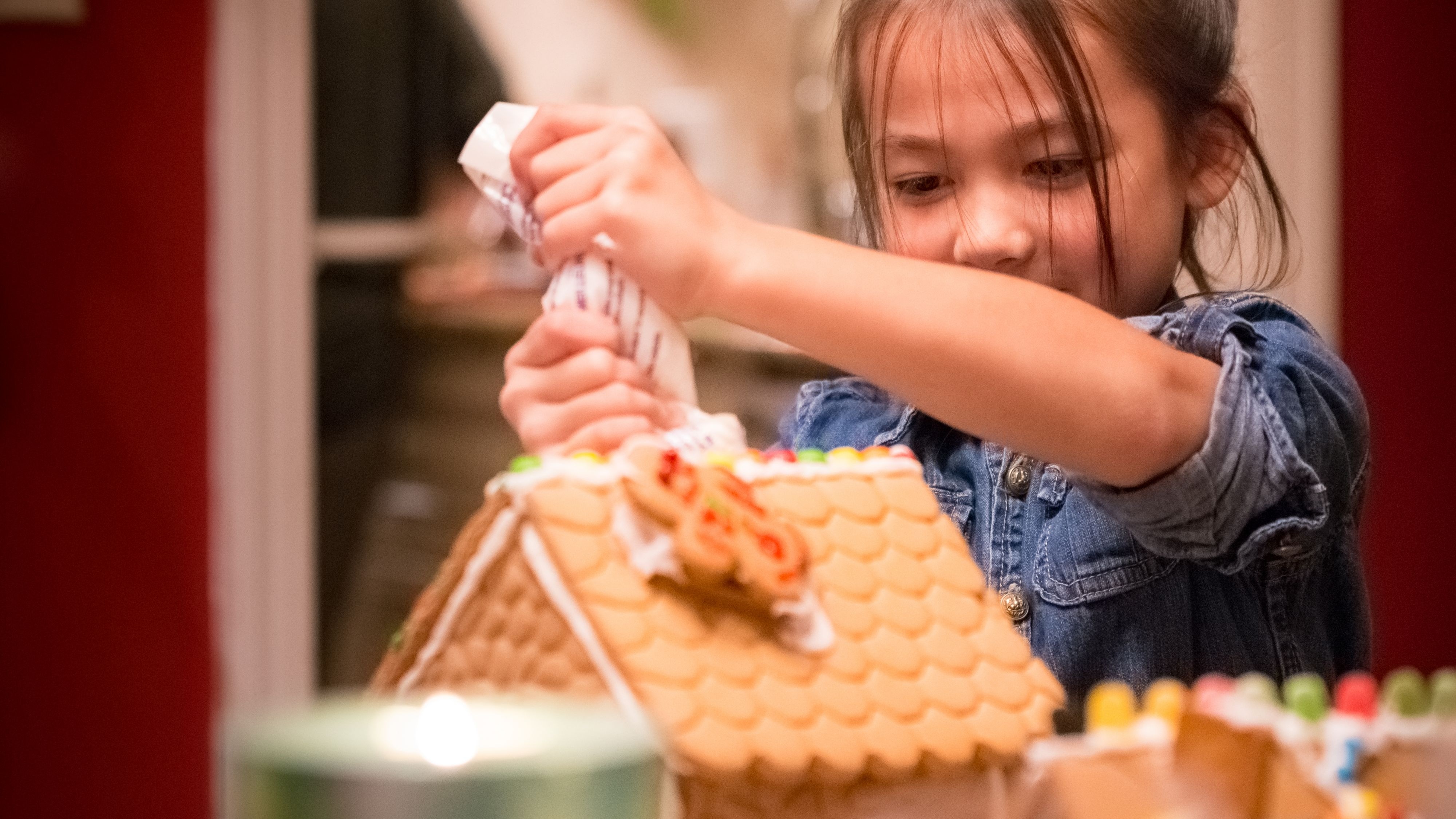 Niña jugando con la casa de pan de jengibre