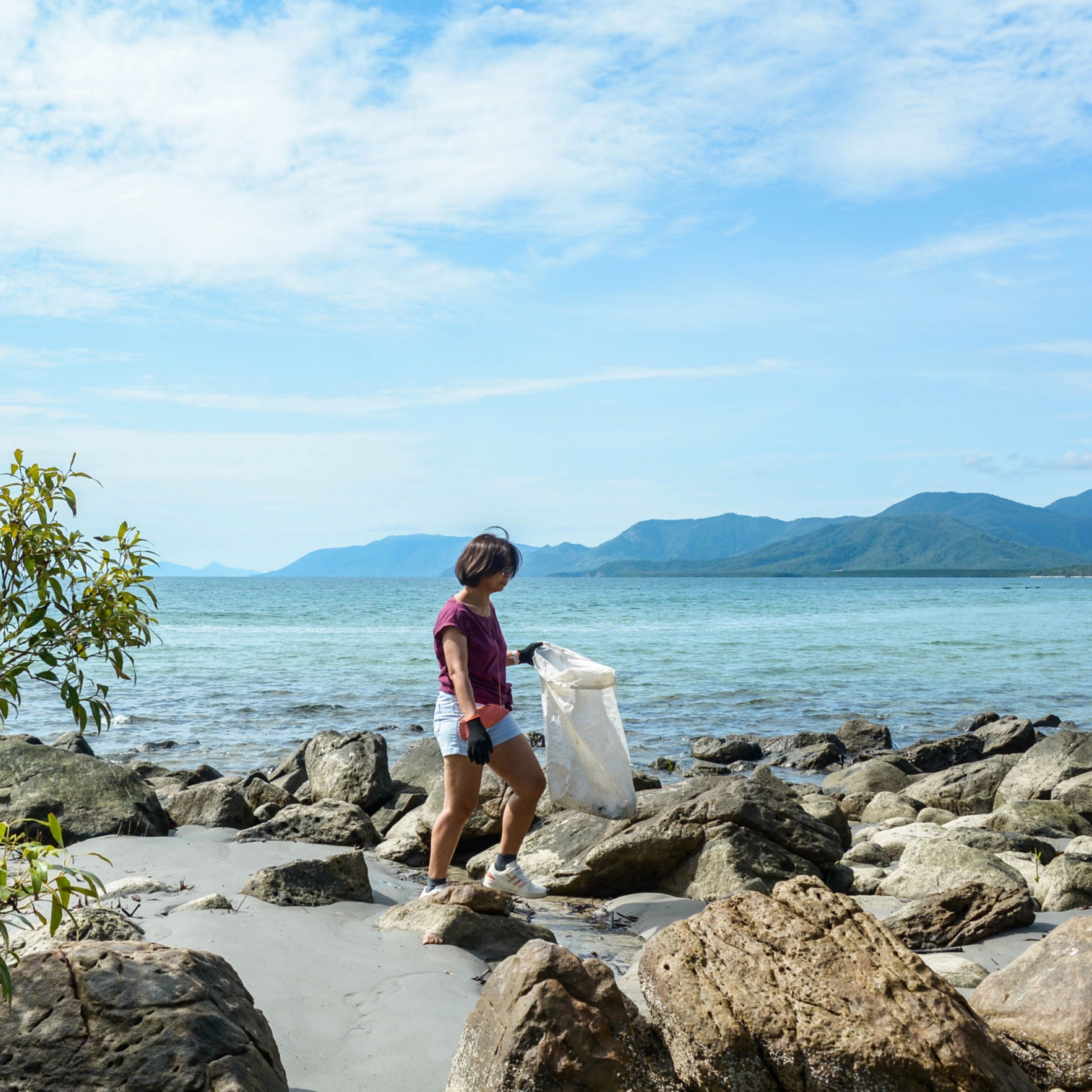 Person looking for litter on the beach.