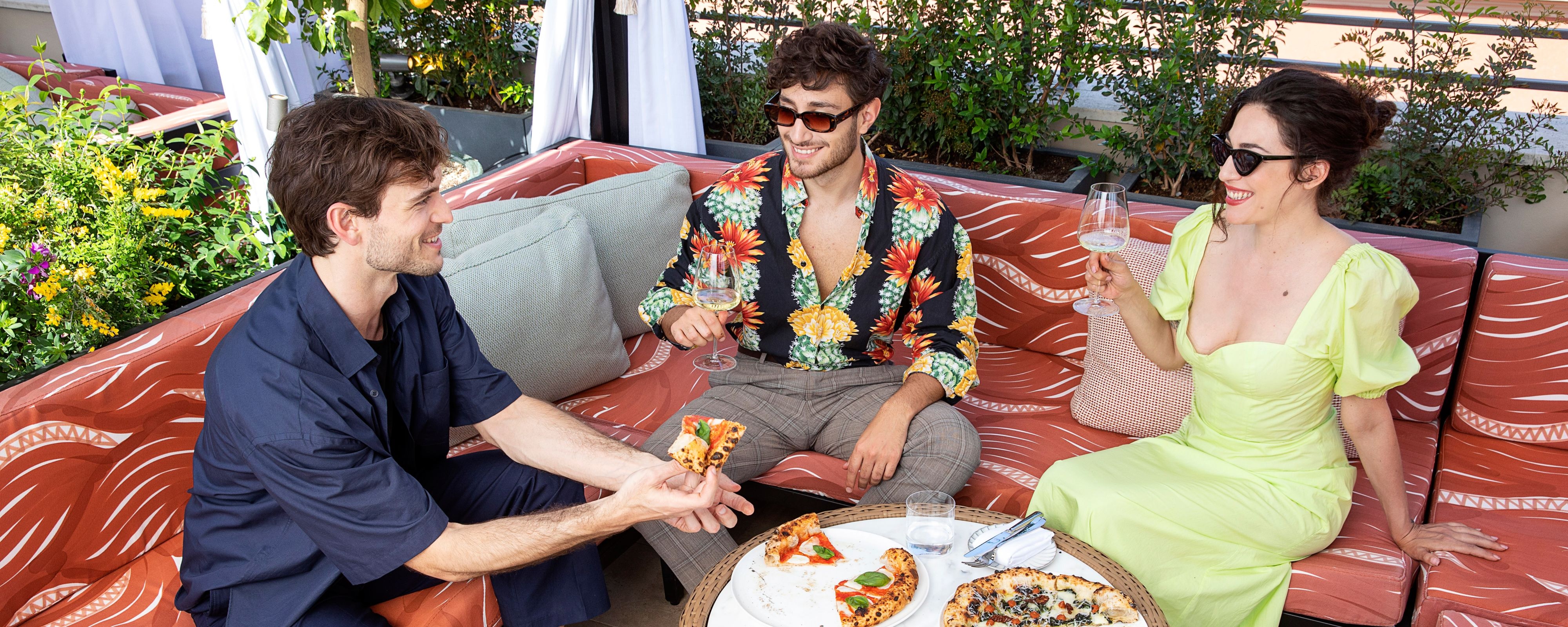 People eating pizza on an outdoor patio