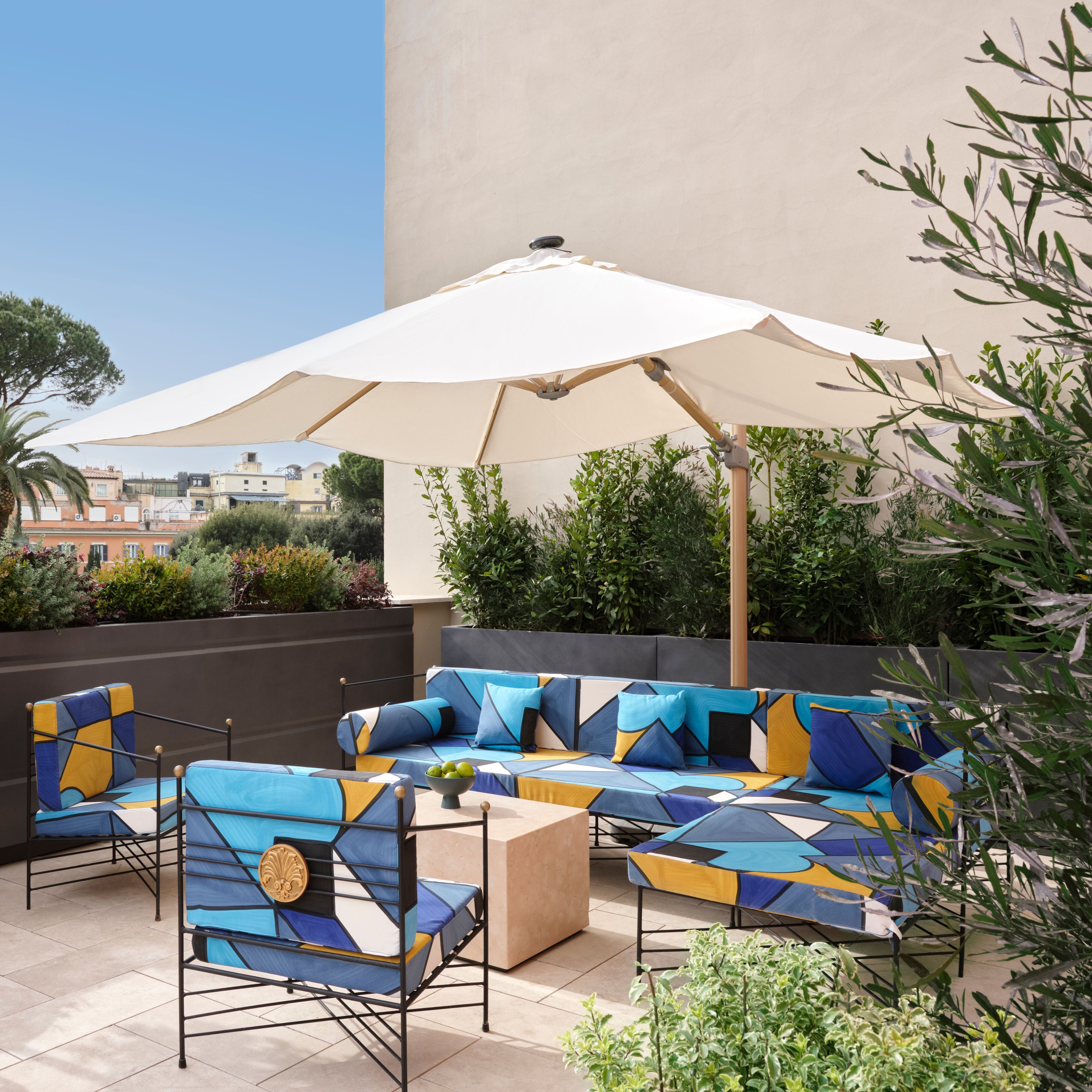 Posti a sedere all'aperto con sedie, divano e ombrellone