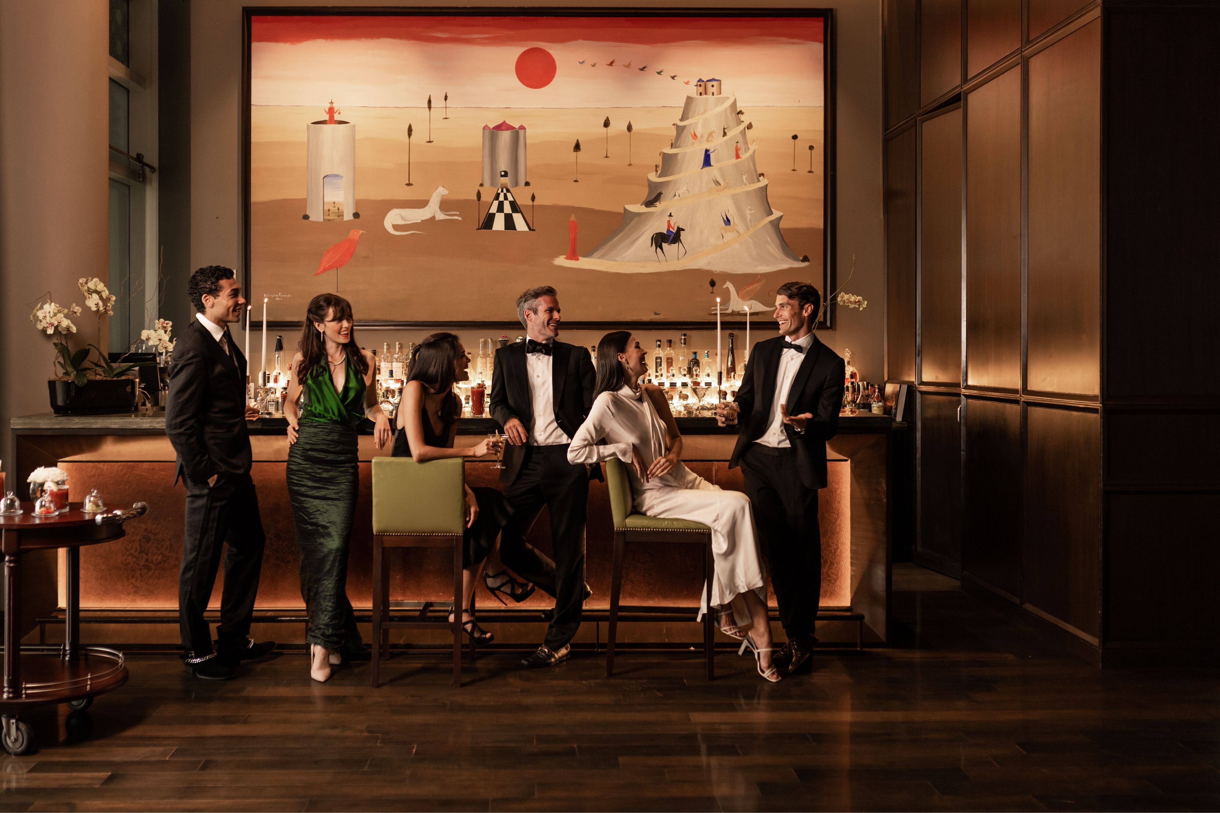 group of friends in black tie attire at the bar